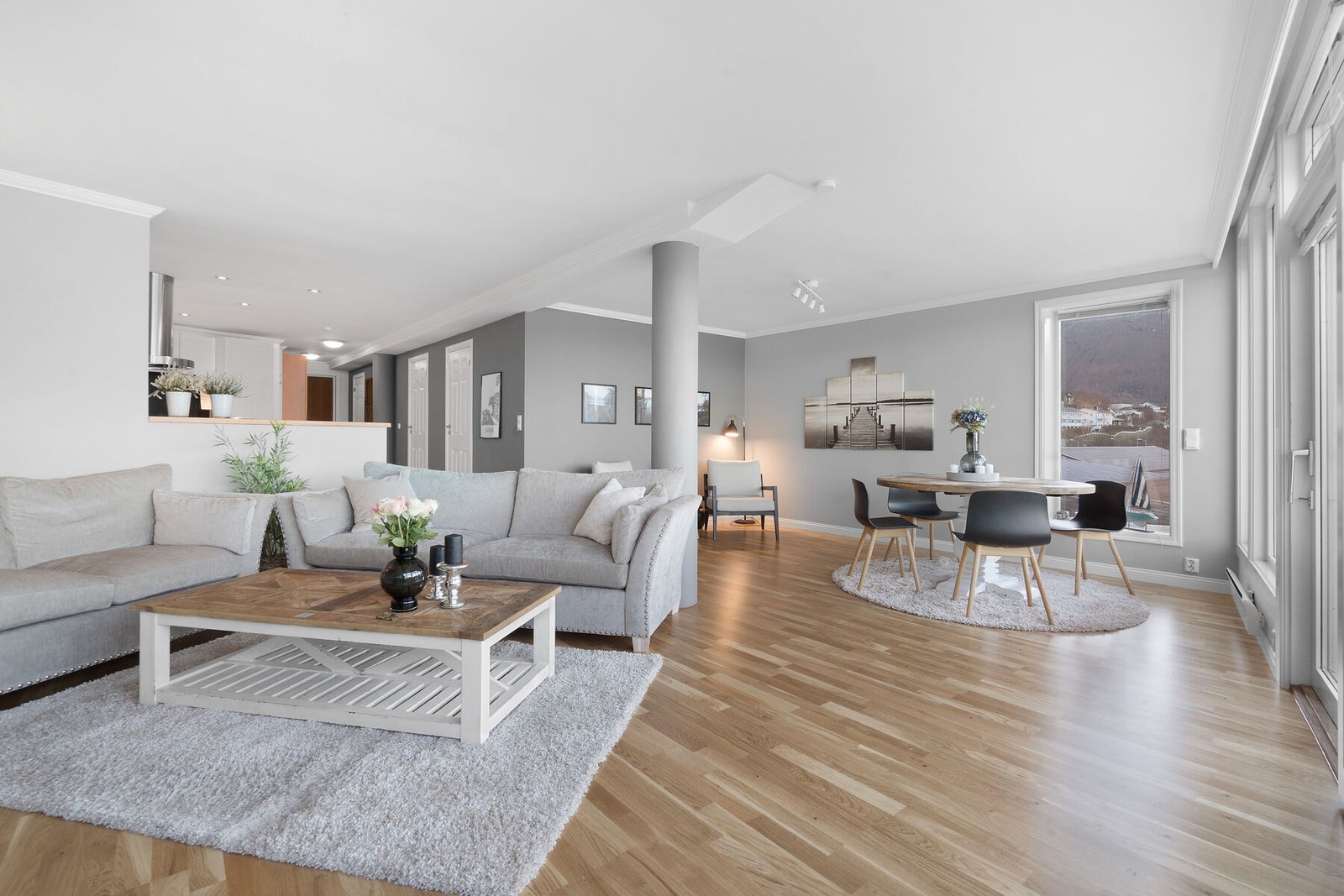 Romslig stue som er innredet med sofagruppe, spisegruppe og lesekrok. Galleribilde