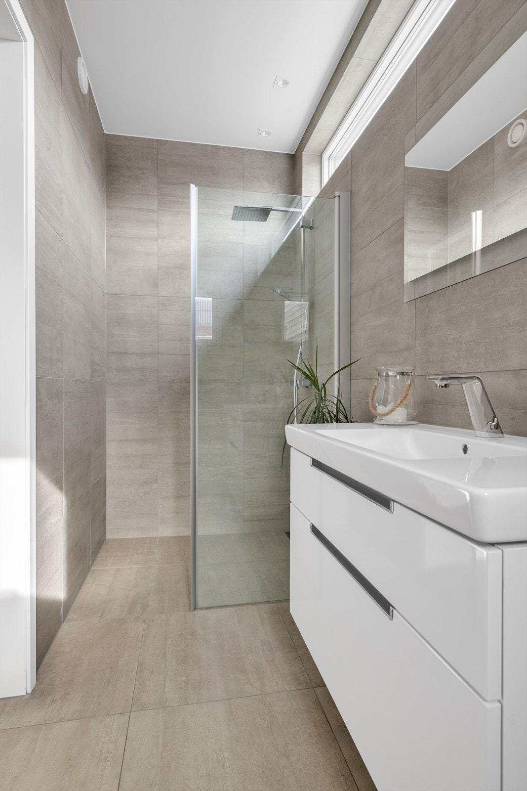 Flislagt baderom med kvalitetsfliser fra Flisekompaniet. Innredning med nedfelt servant, veggmontert toalett og dusj. Gulvvarme og balansert ventilasjon Galleribilde