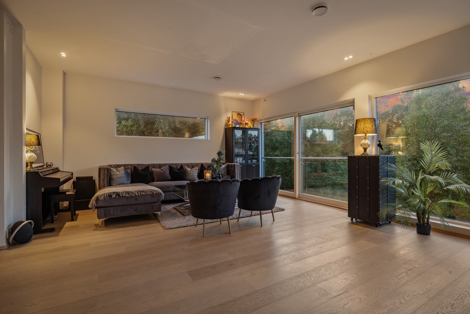 I boligens oppholdsrom legger du umiddelbart merke til de store vinduene som går fra gulv til tak. Galleribilde