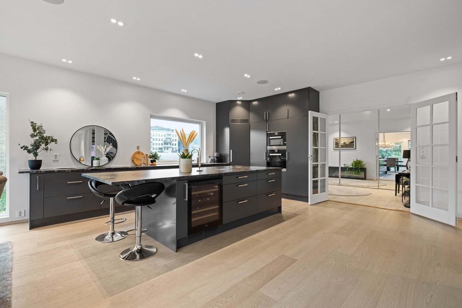 Benkeplate av stein. Integrert kjølehjørne, oppvaskmaskin, stekeovn, kombinert micro/stekeovn, induksjonstopp med flere soner inkl. wok sone. Vinskap. Galleribilde