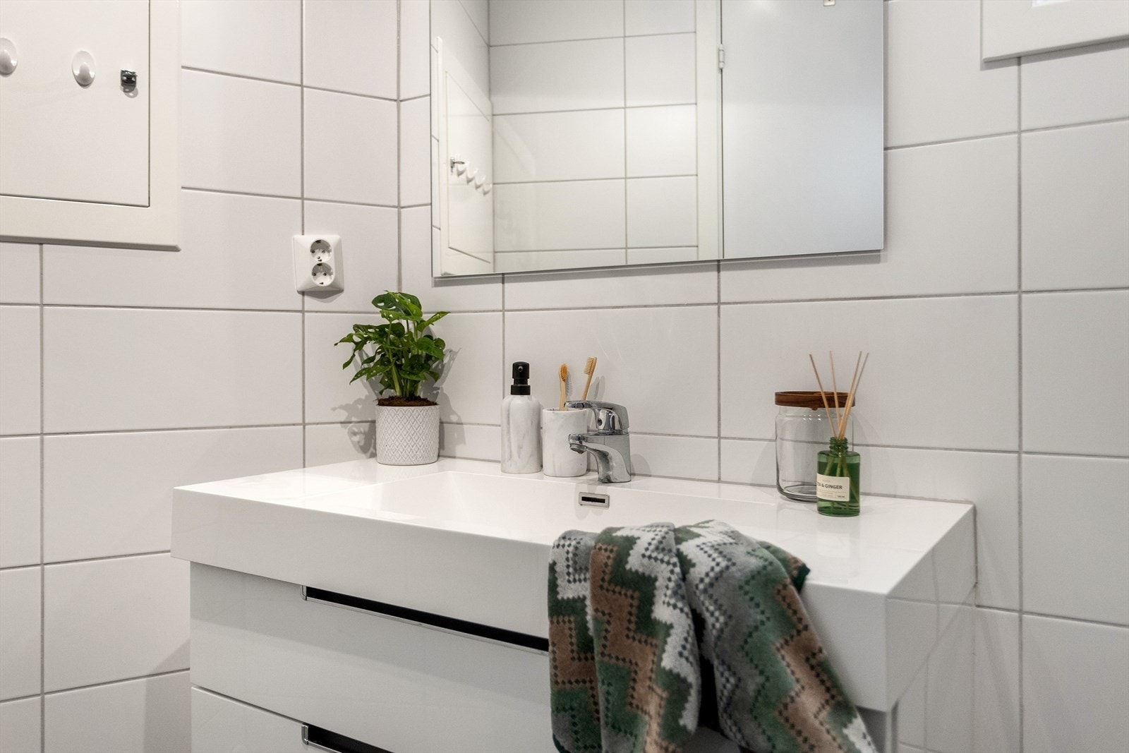 Badet inneholder veggehengt toalett, helstøpt servant, baderomsmøbler og dusjdører i klart glass. Galleribilde