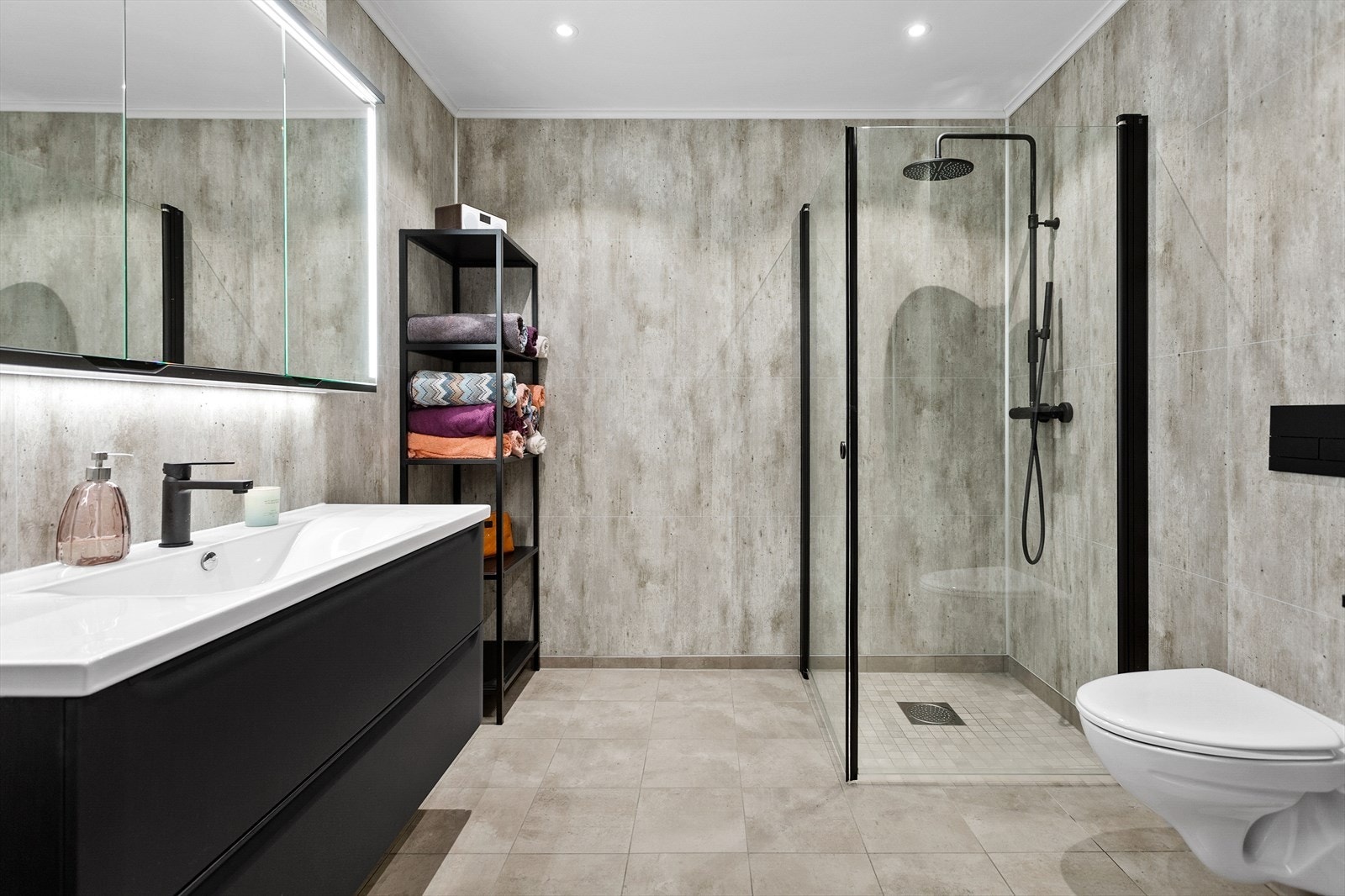 Badet er stilig med romslig innredning og sorte detaljer Galleribilde