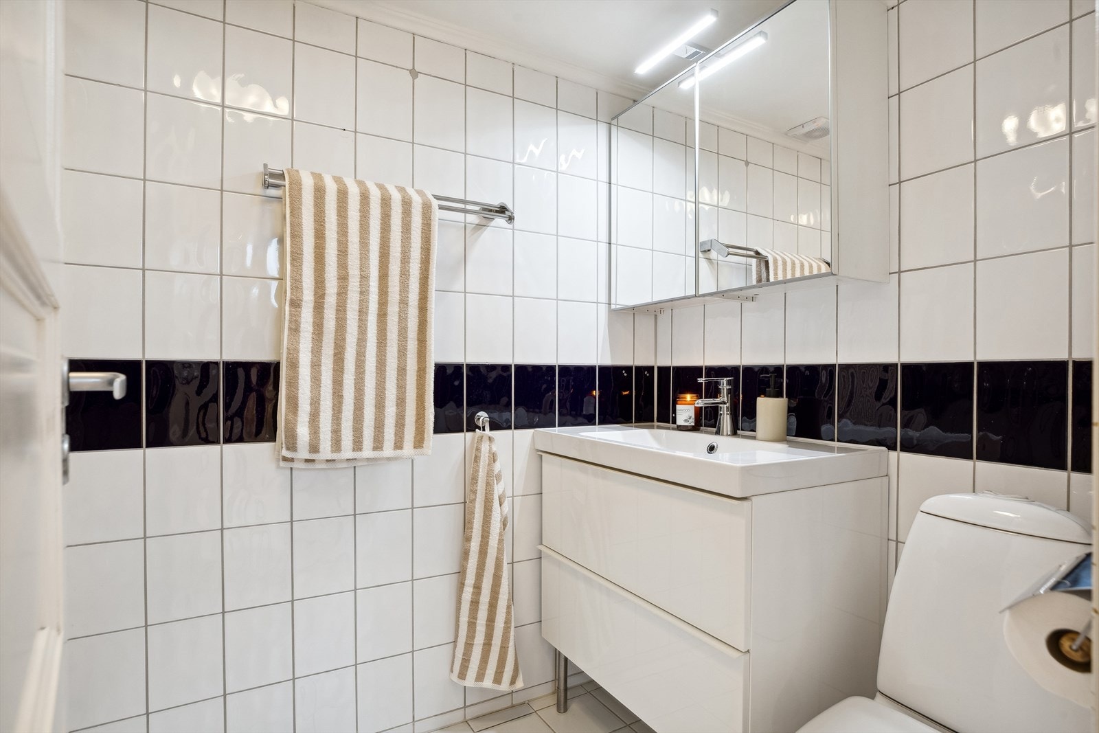 Leiligheten har et flislagt bad med gulvvarme, moderne innredning og praktisk dusjkabinett Galleribilde