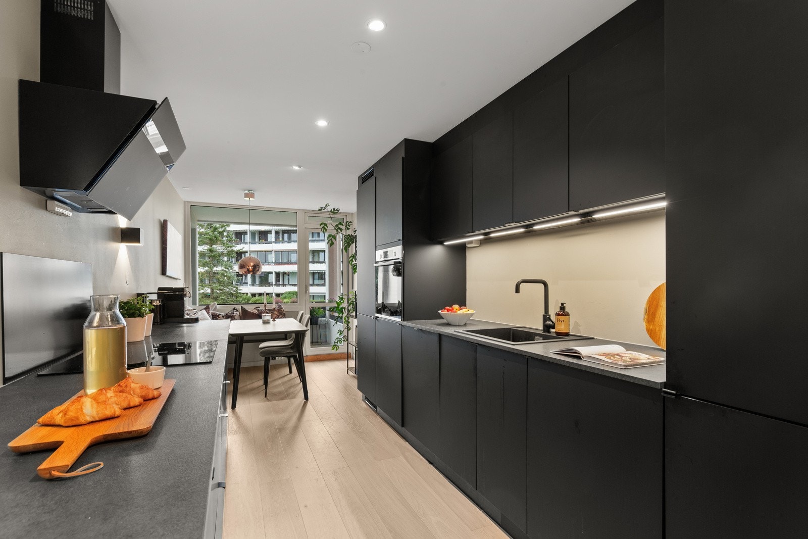 Stilren Kvik kjøkkeninnredning fra 2020 med mørke fronter. Her er det gode naturlige sol- og lysforhold fra flere kanter. Galleribilde