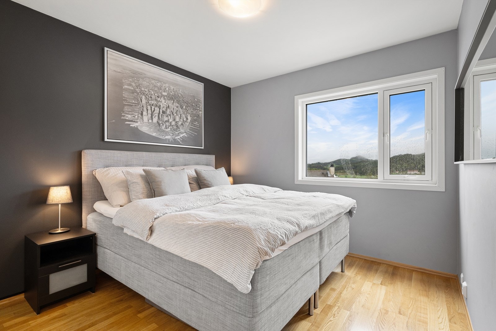 Hovedsoverommet er plassert ytterst på hjørnet. Hovedsoverommet har parkett på gulvet med matchende gulvlister, slette, gråmalte vegger og en fondvegg i dempet sort. Et tofagsvindu skaper en fin ramme mot vakker natur og bidrar til gode luftemuligheter. Galleribilde