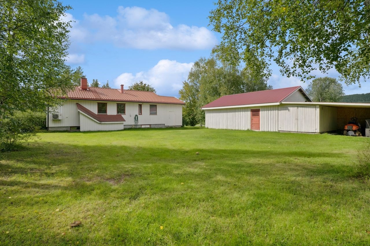 Stor hage bak bolig og mot garasje/uthus. Galleribilde