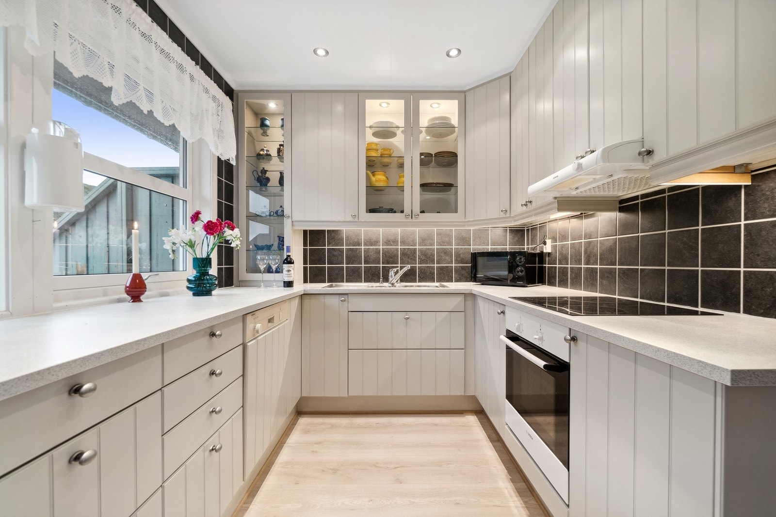 Lekkert kjøkken med profilerte fronter i tidsriktige farger. Benkeplate i slitesterk laminat. Galleribilde