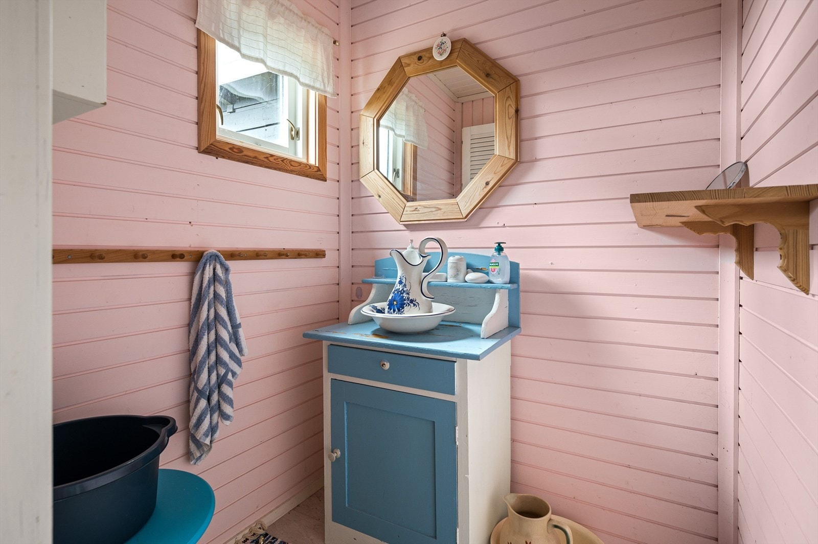 Rommet har panel på veggene malt i en søt rosafarge og en sjarmerende innredning med speil over. Galleribilde