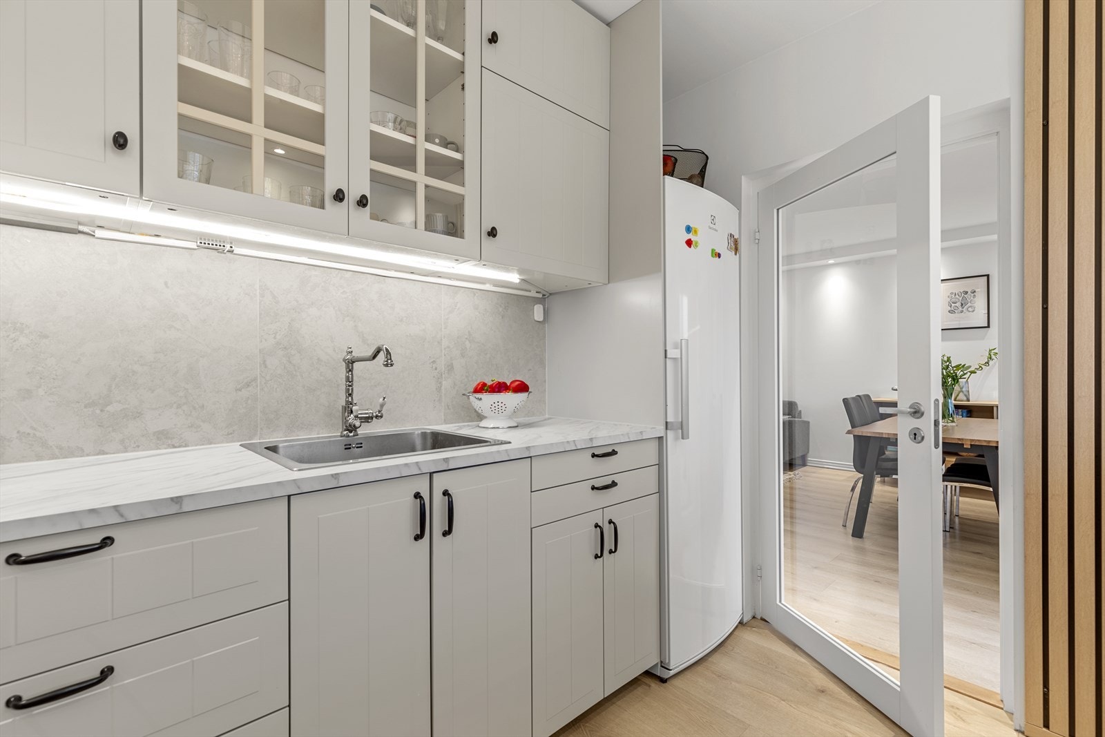 Kjøkkenet er innredet med nedfelt servant, integrerte hvitevarer som komfyr, platetopp. Galleribilde