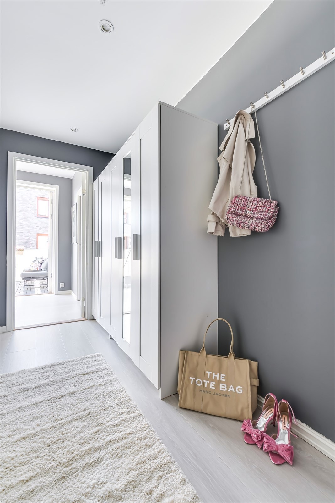 En lys og innbydende entré/gang hvor det er gode oppbevaringsmuligheter for yttetøy og sko i garderobeskap og knagger på vegg. Galleribilde