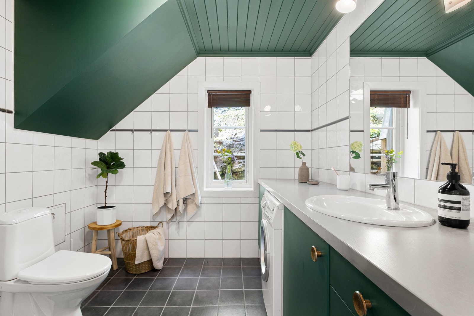 Pent, tidsriktig bad med dusjnisjé med innfellbare dusjvegger, toalett, servant med god skapplass og opplegg for vaskemaskin under praktisk benk Galleribilde