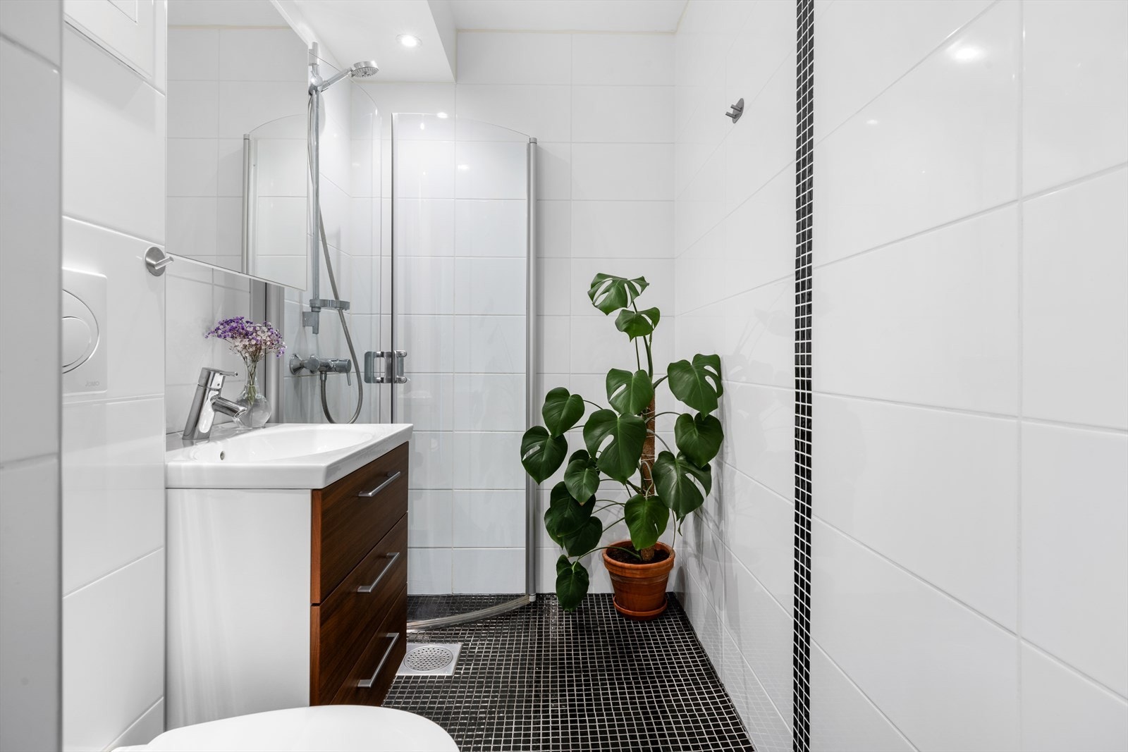 - Badet er innredet med veggehengt toalett, benkeskap med servant og dusjhjørne - Galleribilde