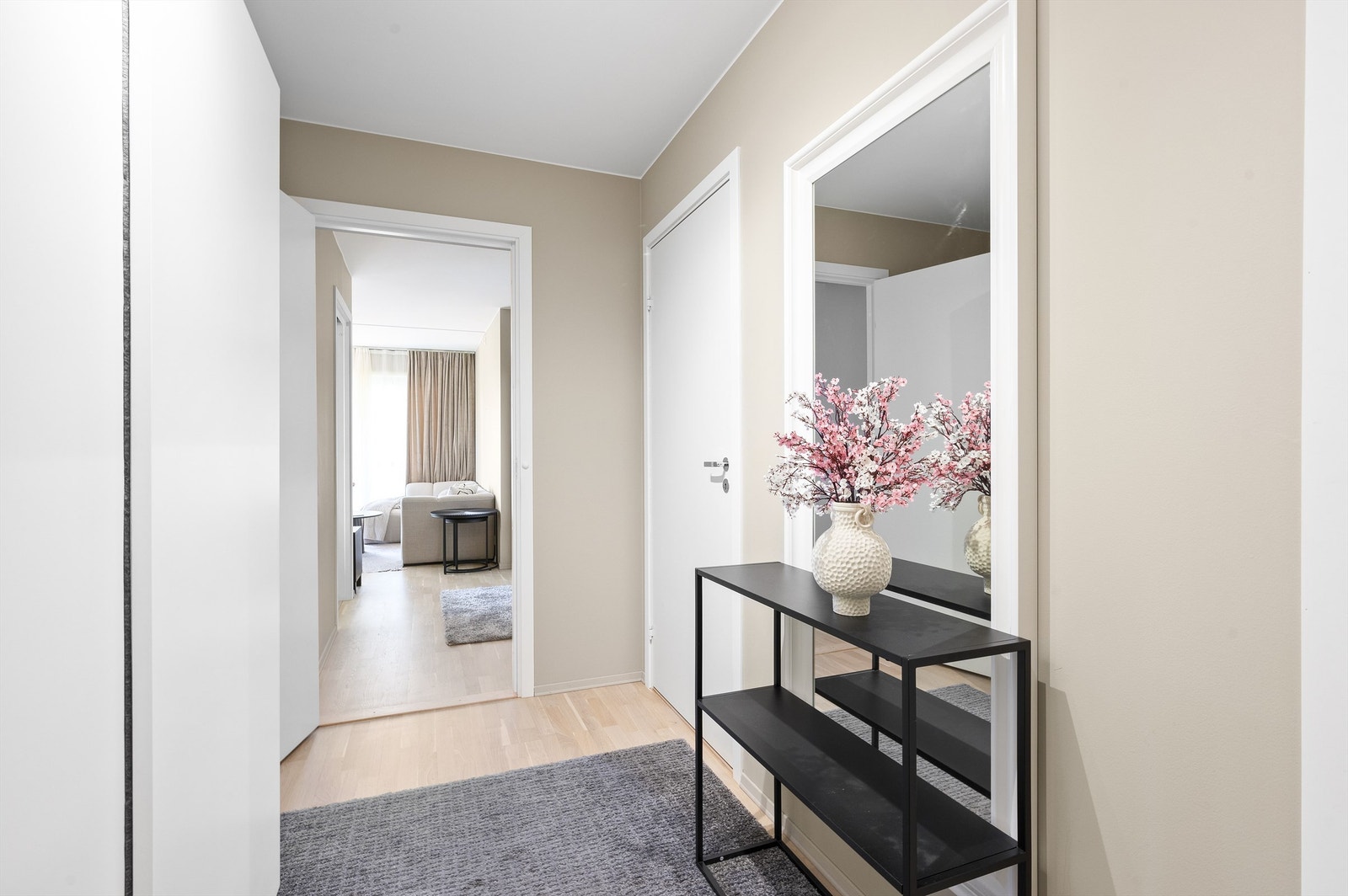 Flott entré med en kombinasjon av lysmalte veggflater og lekker, slipt parkett på gulv. Galleribilde