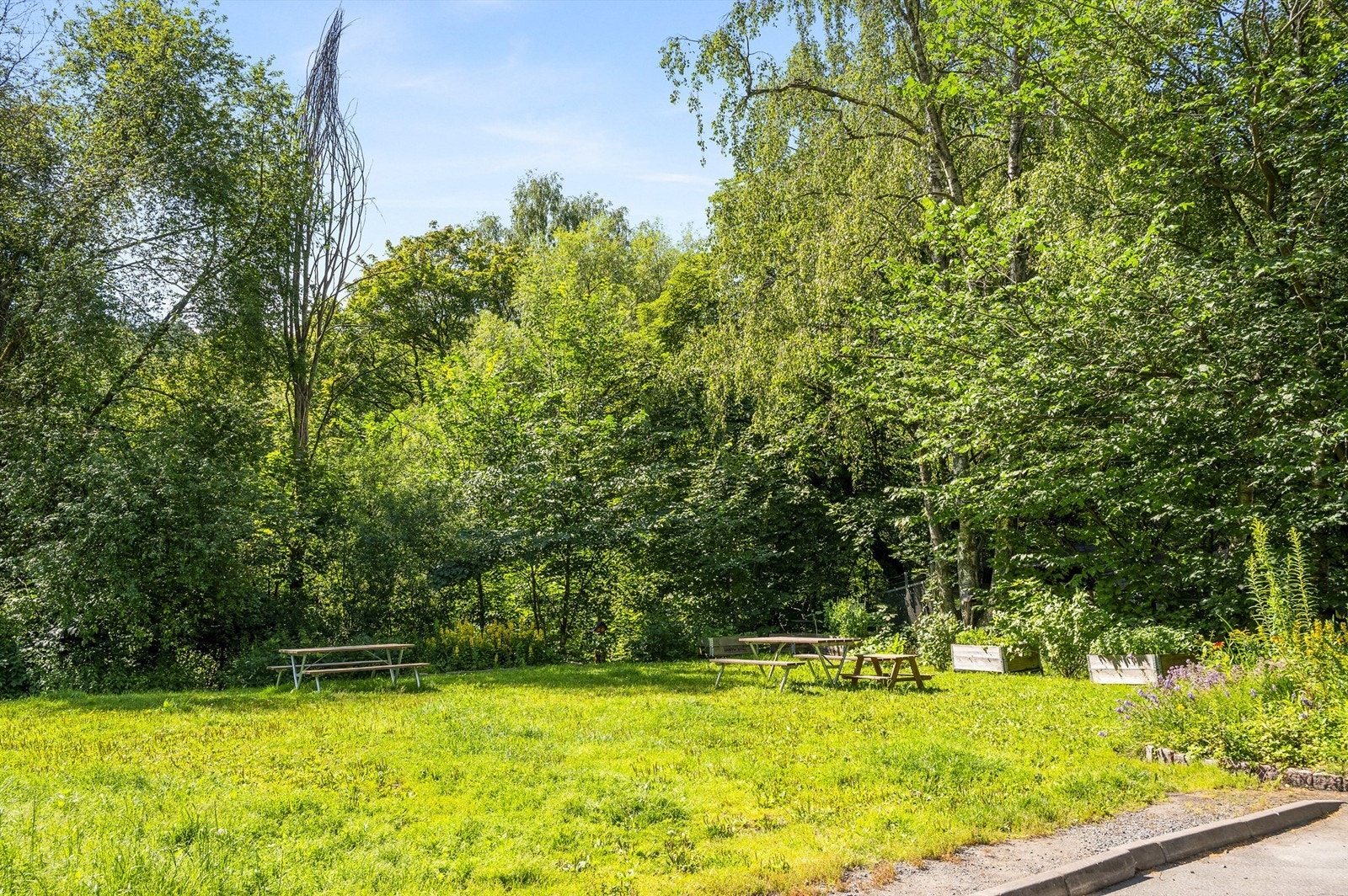 Tomten til borettslaget er opparbeidet med plenarealer, prydbusker, beplantninger, trær, lekeplass og sittebenker Galleribilde