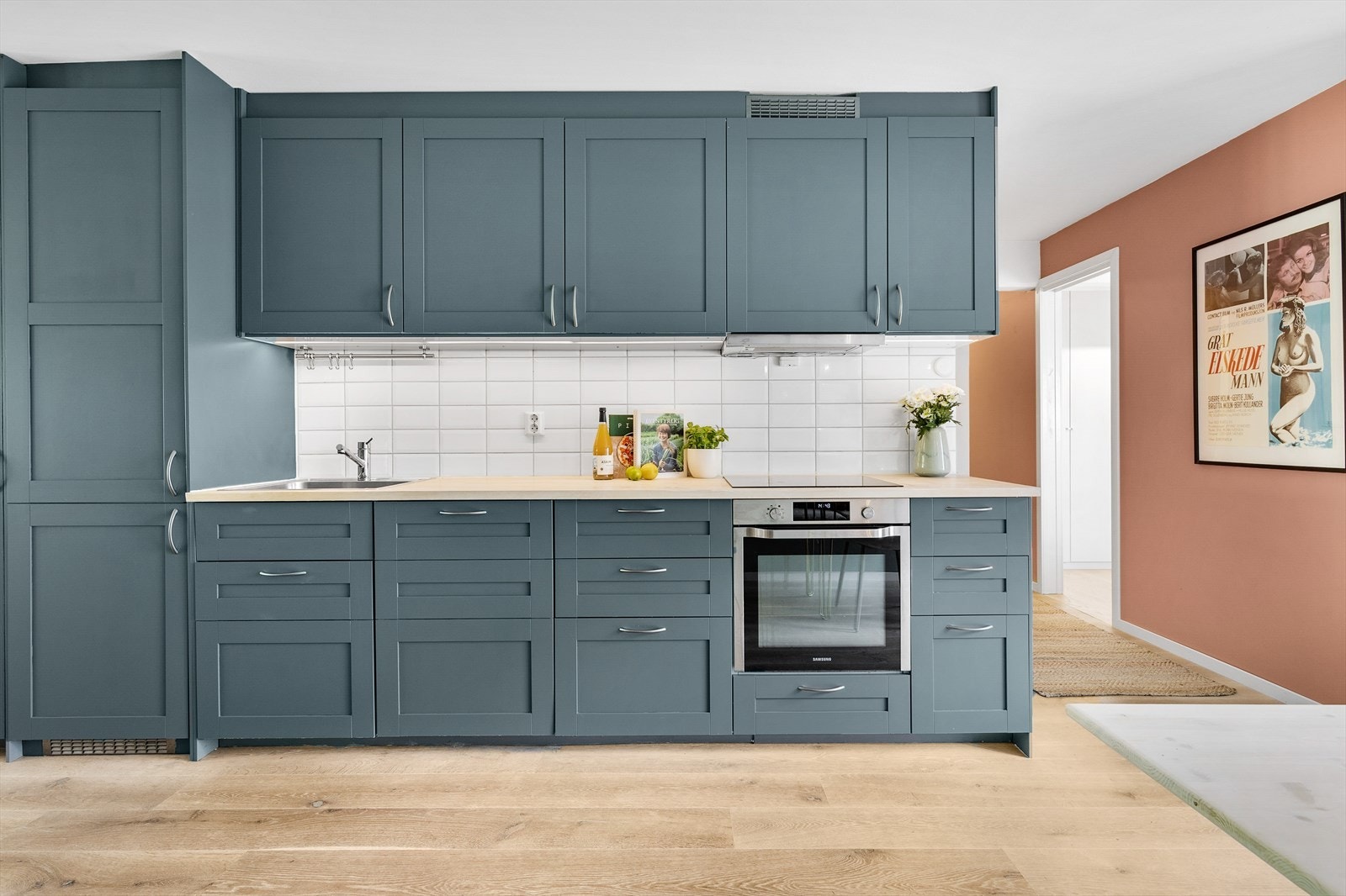 Lekkert kjøkken med integrerte hvitevarer som kjøl- og fryseskap, stekeovn, induksjonsplatetopp og oppvaskmaskin. Galleribilde