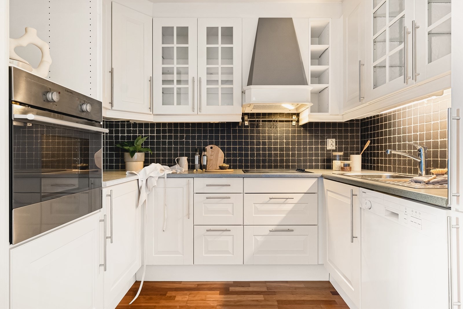 Kjøkken med hvit profilert innredning. Integrert stekeovn, kjøleskap/frys og platetopp. Galleribilde