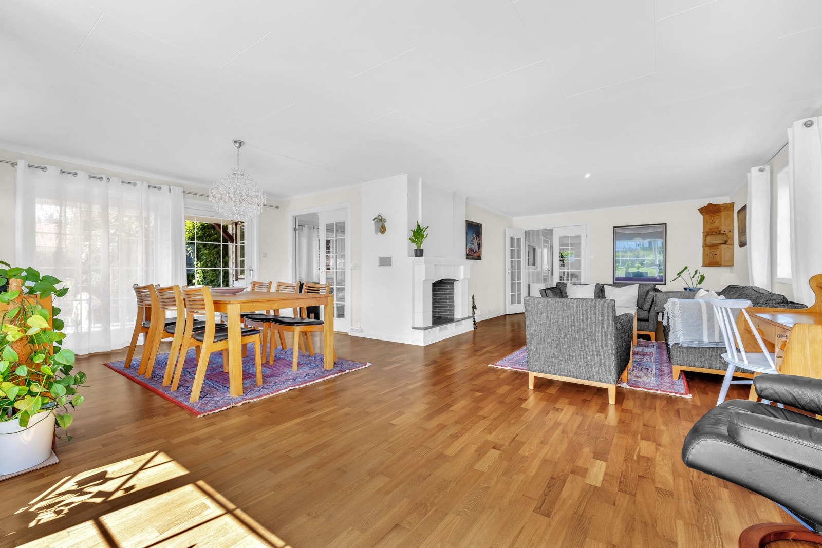 Stuen har parkettgulv, lysmalte overflater og store vinduer. Galleribilde