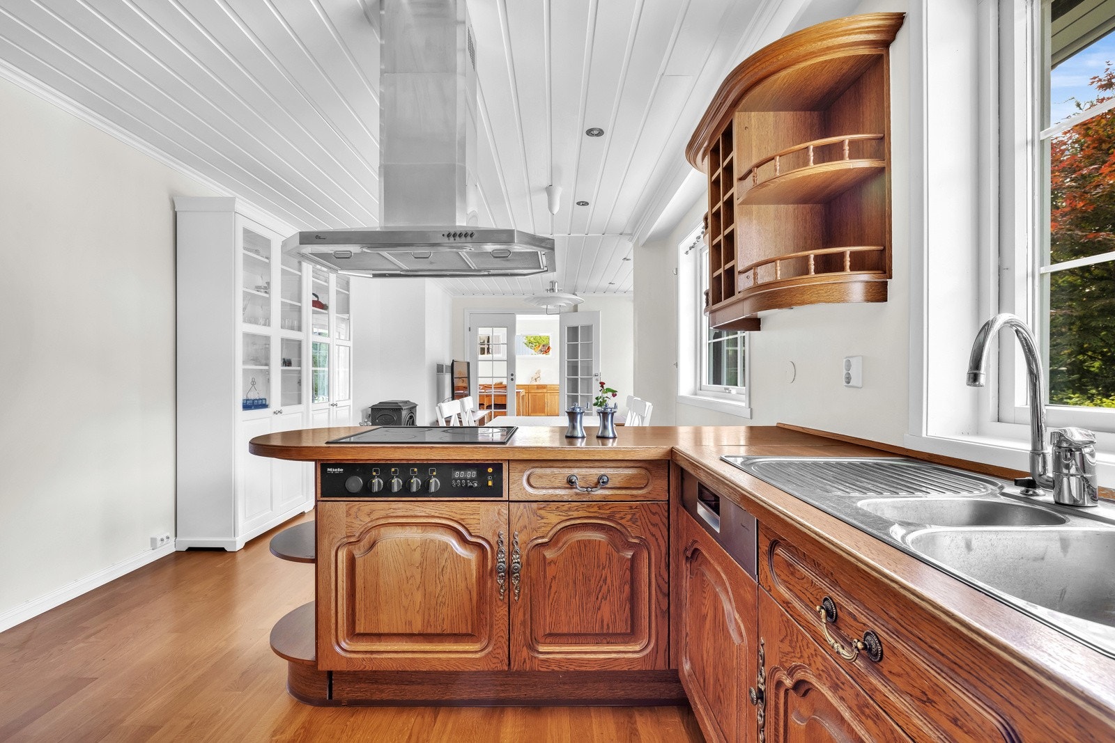 En stilig barløsning skaper et naturlig skille mellom spisestuedelen og resten av kjøkkenet. Galleribilde