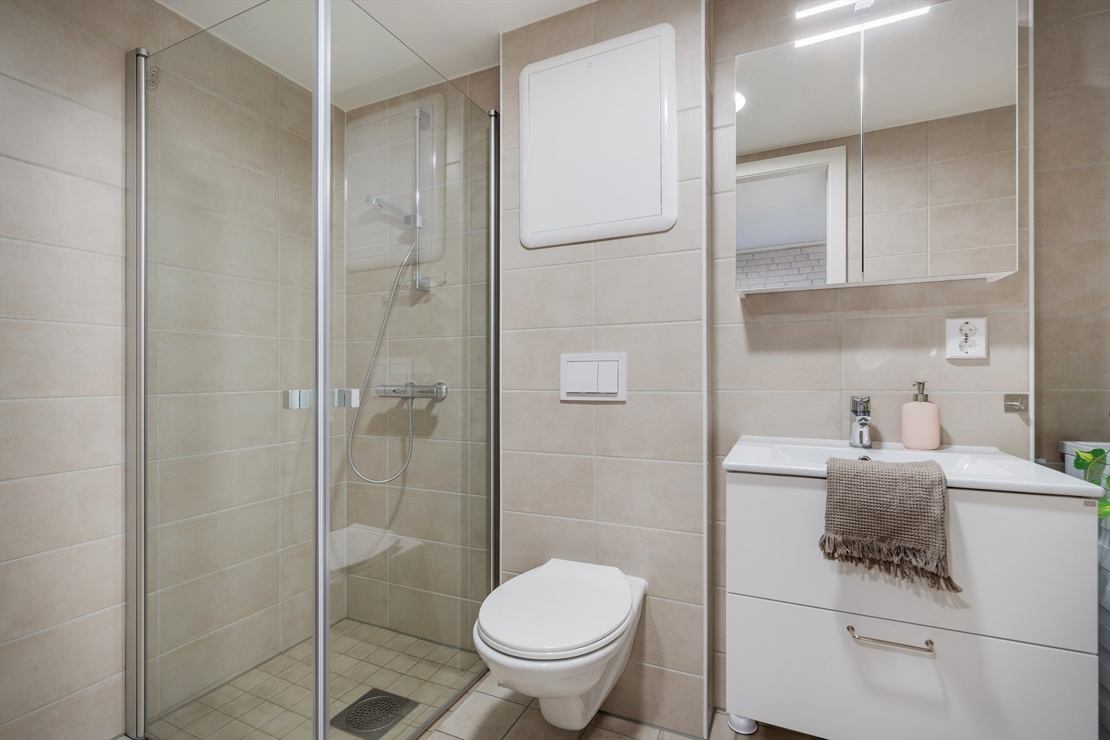 - Badet er helfliset og innredet med dusj, vegghengt wc, servant med badromsmøbel, speilskap og opplegg til vaskemaskin - Galleribilde