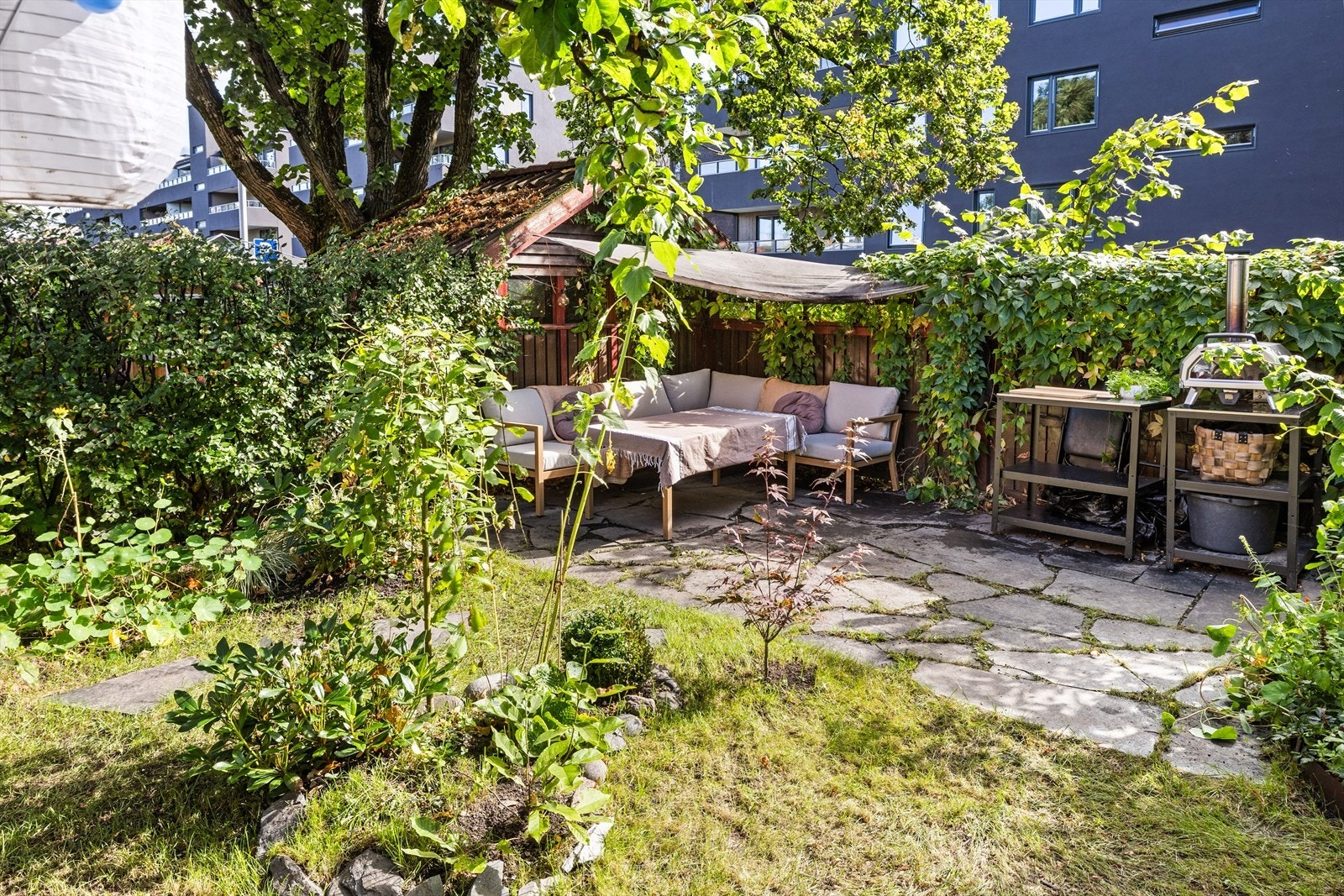 Pent opparbeidet hage på baksiden av huset som vender mot åpent friareal i borettslaget. Galleribilde