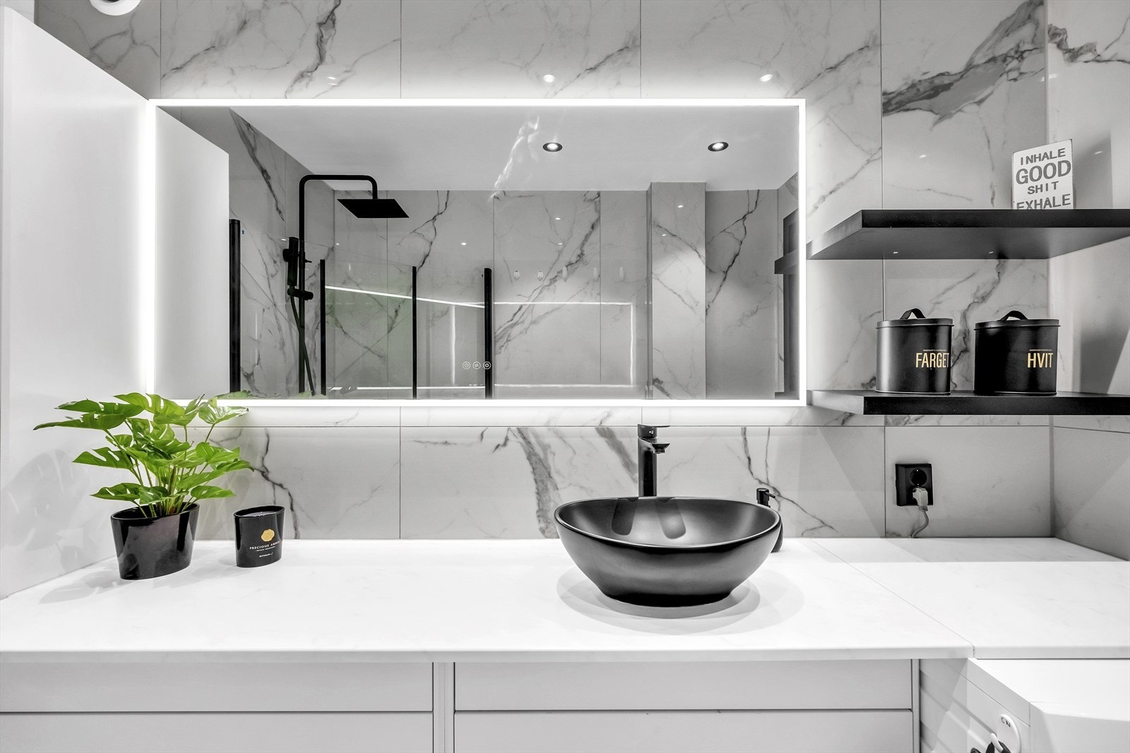 Badet er innredet med servant plassert på benkeplate, speilskap m/lys og dusjhjørne med svingbare glassdører. Galleribilde