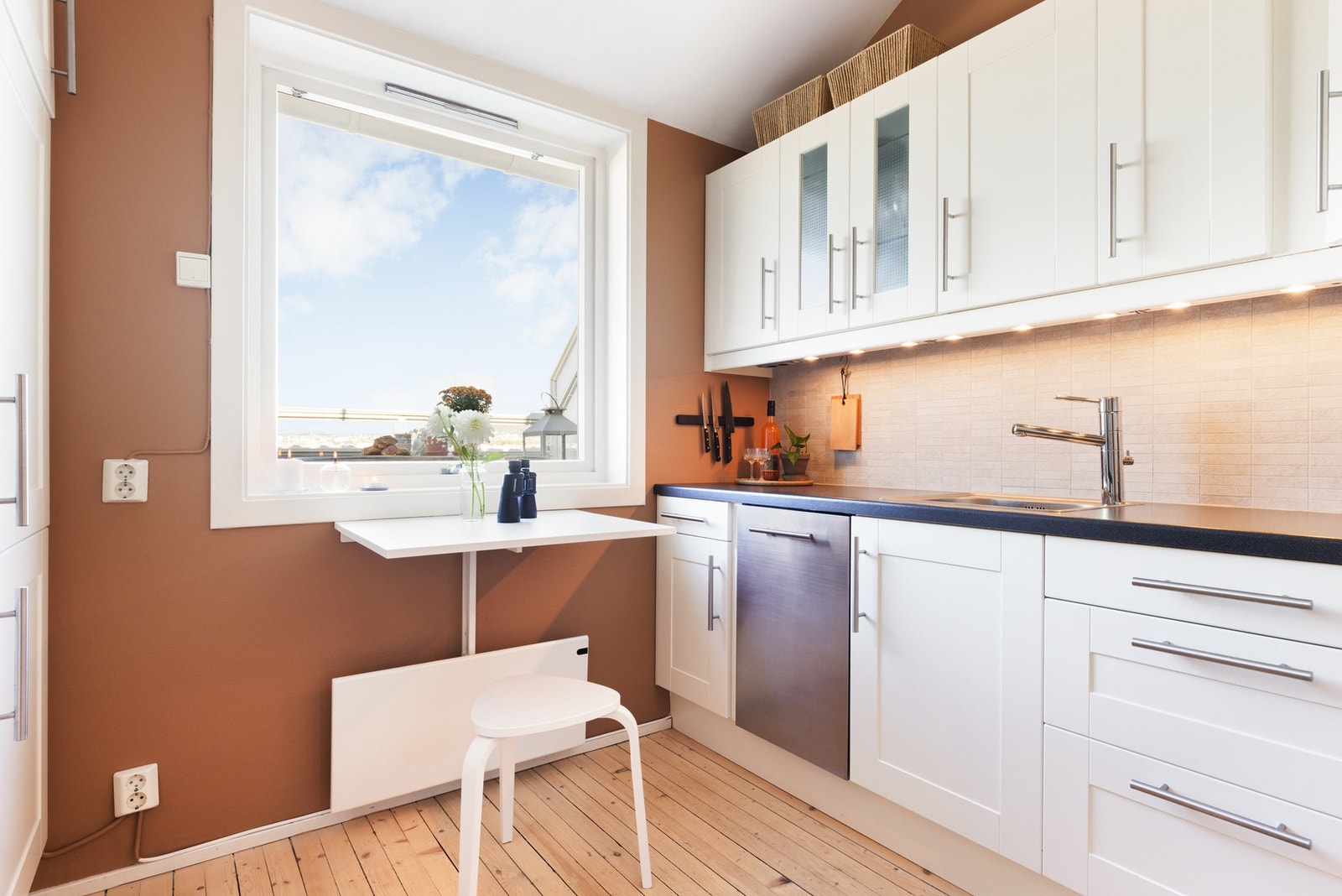 Kjøkkeninnredningen har fabrikklakkerte fronter og laminat benkeplate med nedfelt oppvaskkum og nedfelt koketopp. Galleribilde