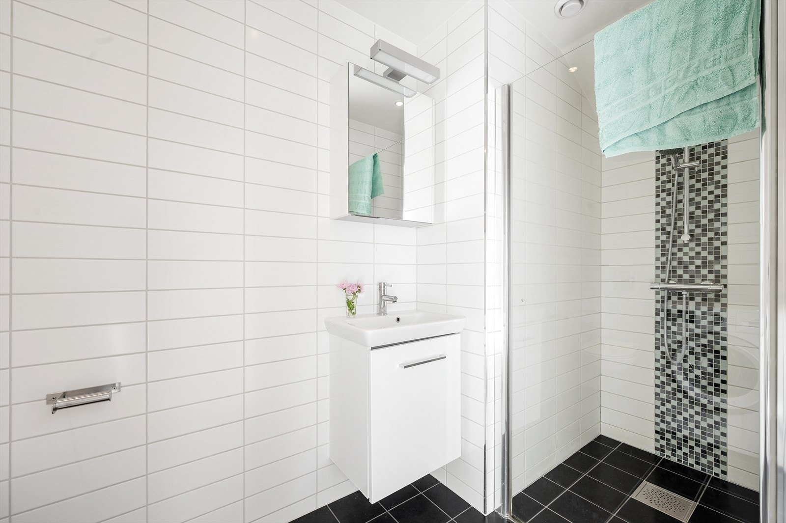 Badet har innredning med nedfelt servant, veggmontert toalett og dusjvegger/hjørne. Galleribilde