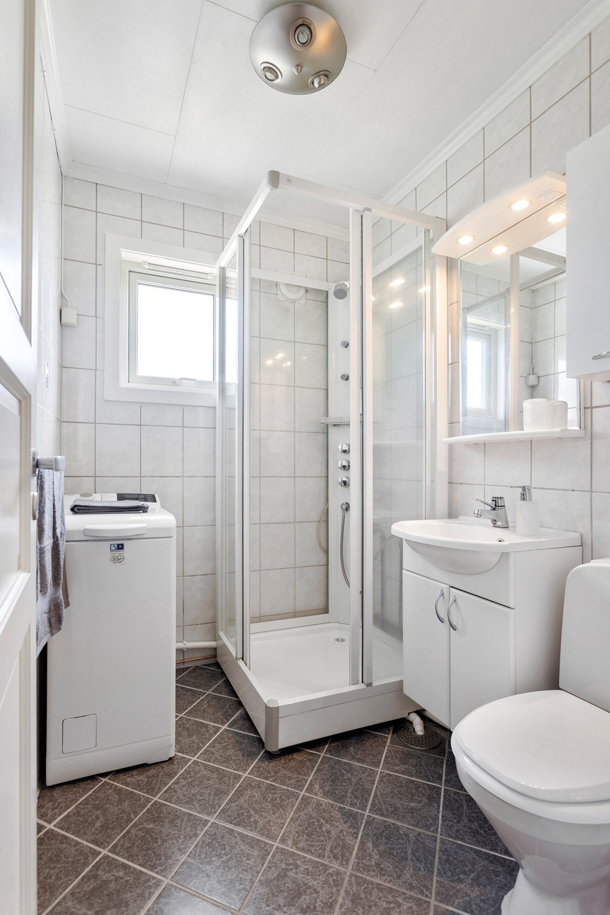 Badet har dusjkabinett, toalett og opplegg for vaskemaskin. Galleribilde