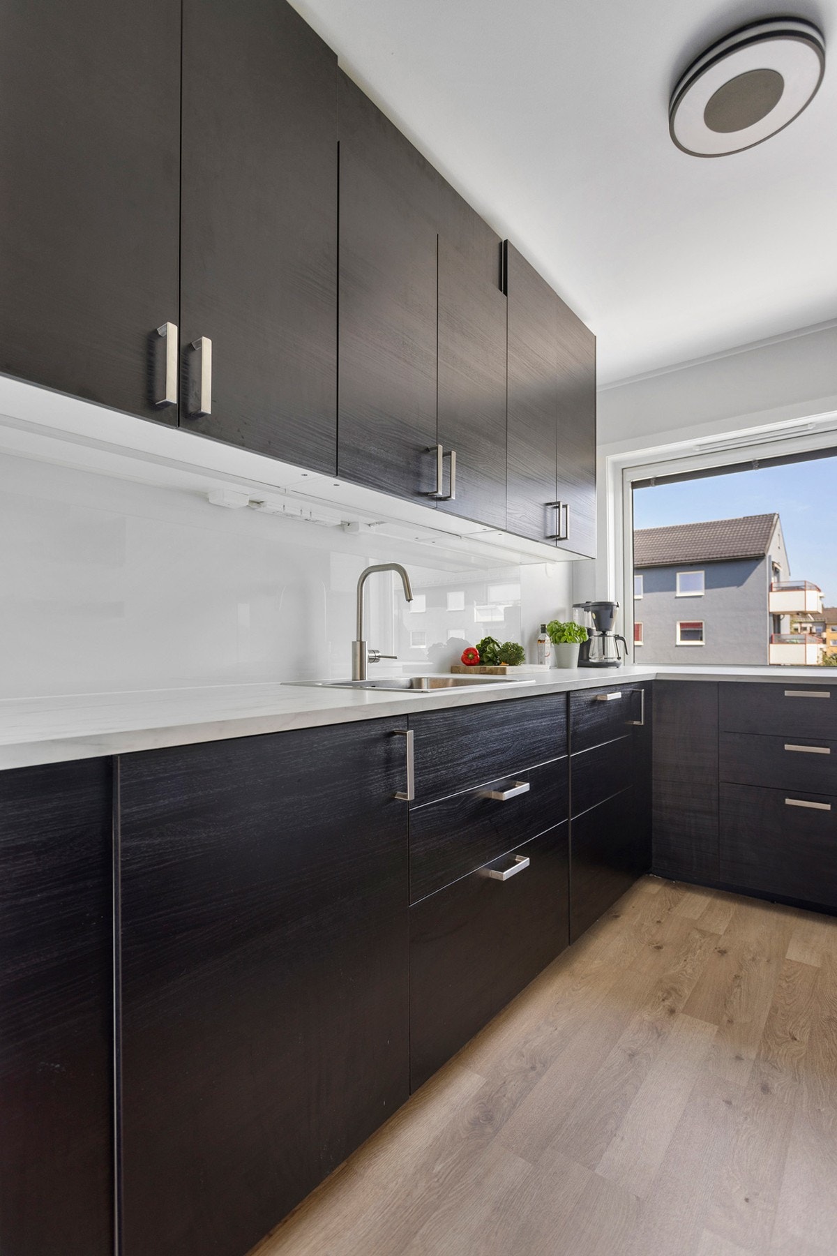 Delikat og moderne kjøkkeninnredning med slette fronter og laminat benkeplate. Galleribilde