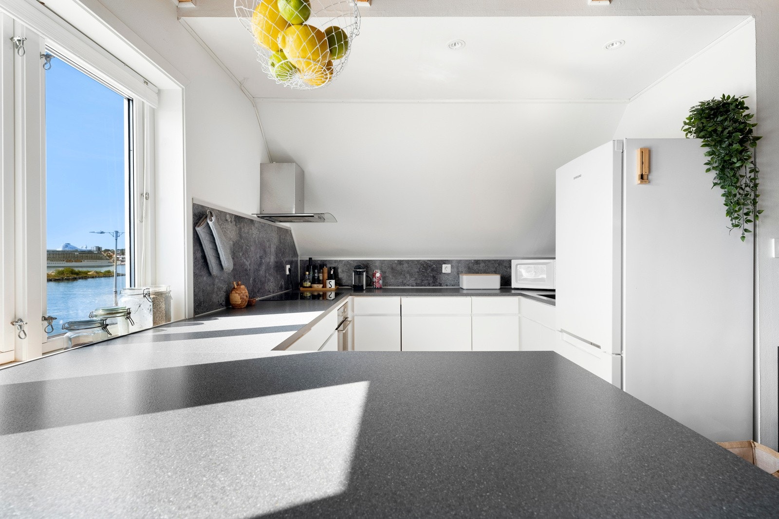 Kjøkkenet ligger i åpen løsning med stuen og man har deilig sjøutsikt, rett fra kjøkkenvinduet. Galleribilde