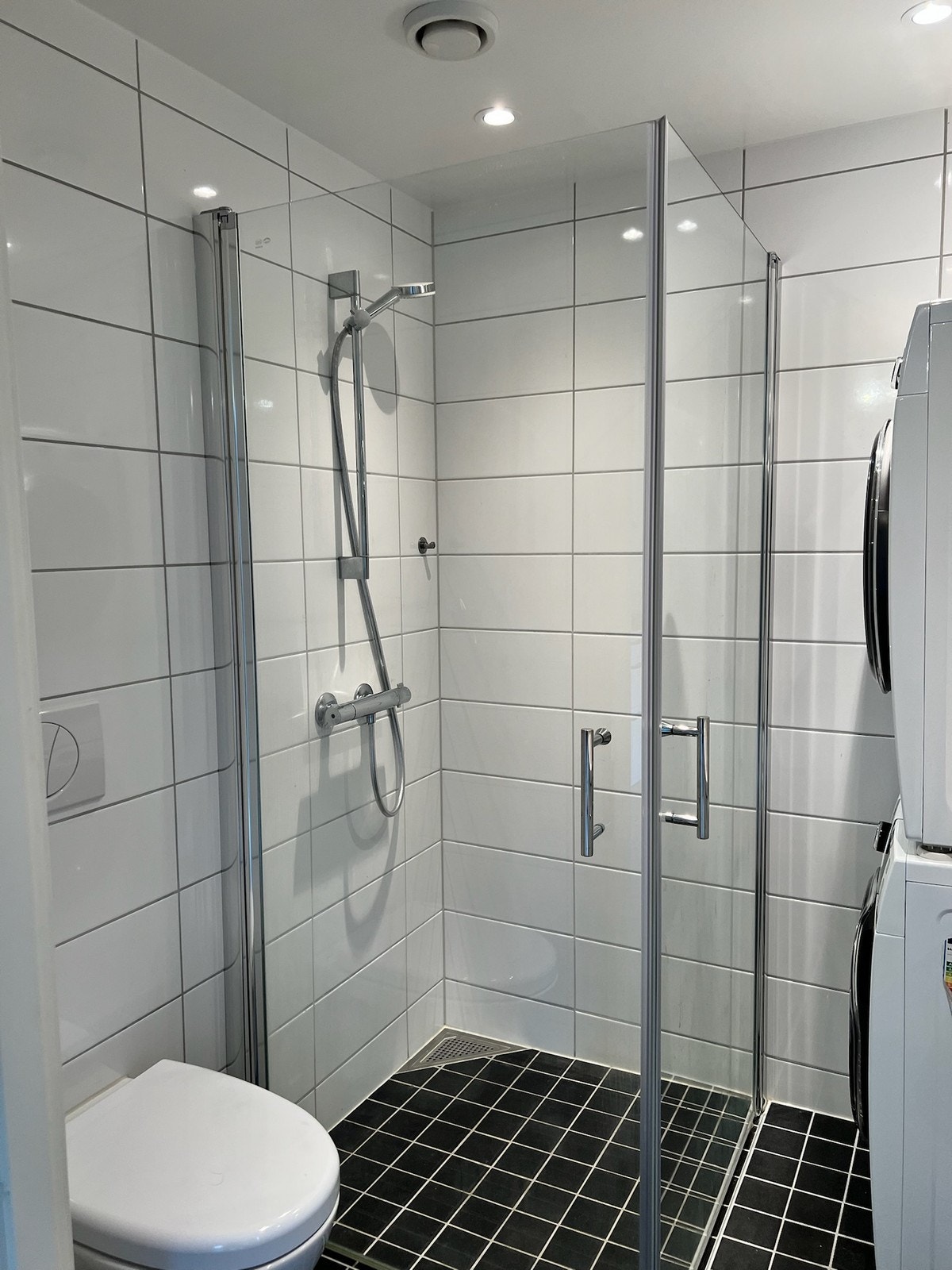 Flislagt bad med fellbare dusjdører. Galleribilde