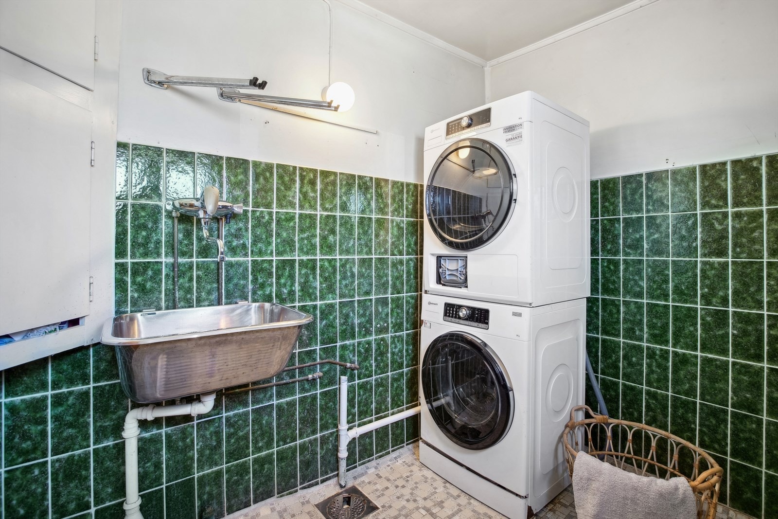 Vaskerommet er enkelt innredet med utslagsvask, veggskap og opplegg for vaskemaskin. Galleribilde