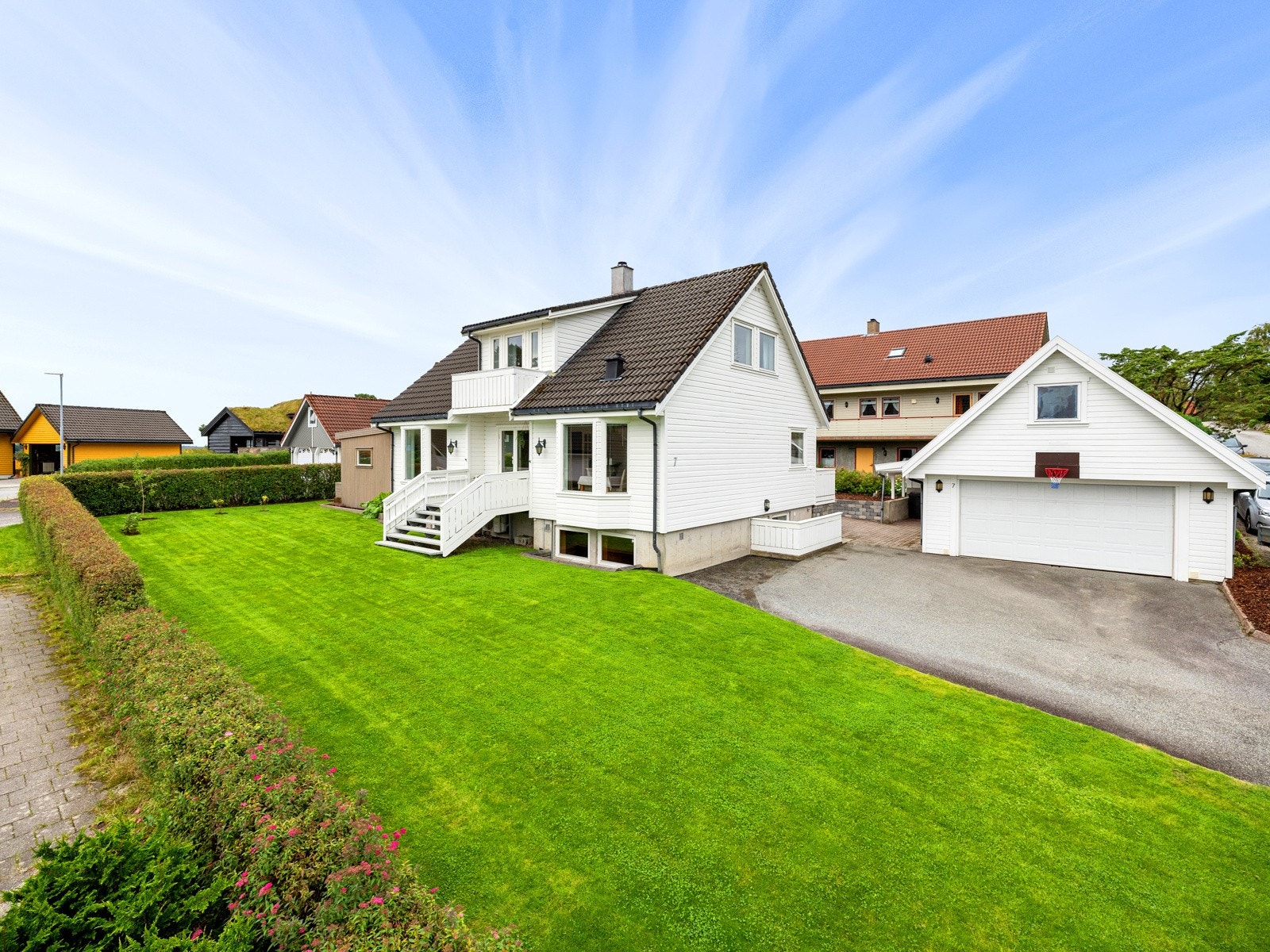 Tomten er flott opparbeidet plen, belegningsstein, terrasseflater, grus og busker/planter Galleribilde