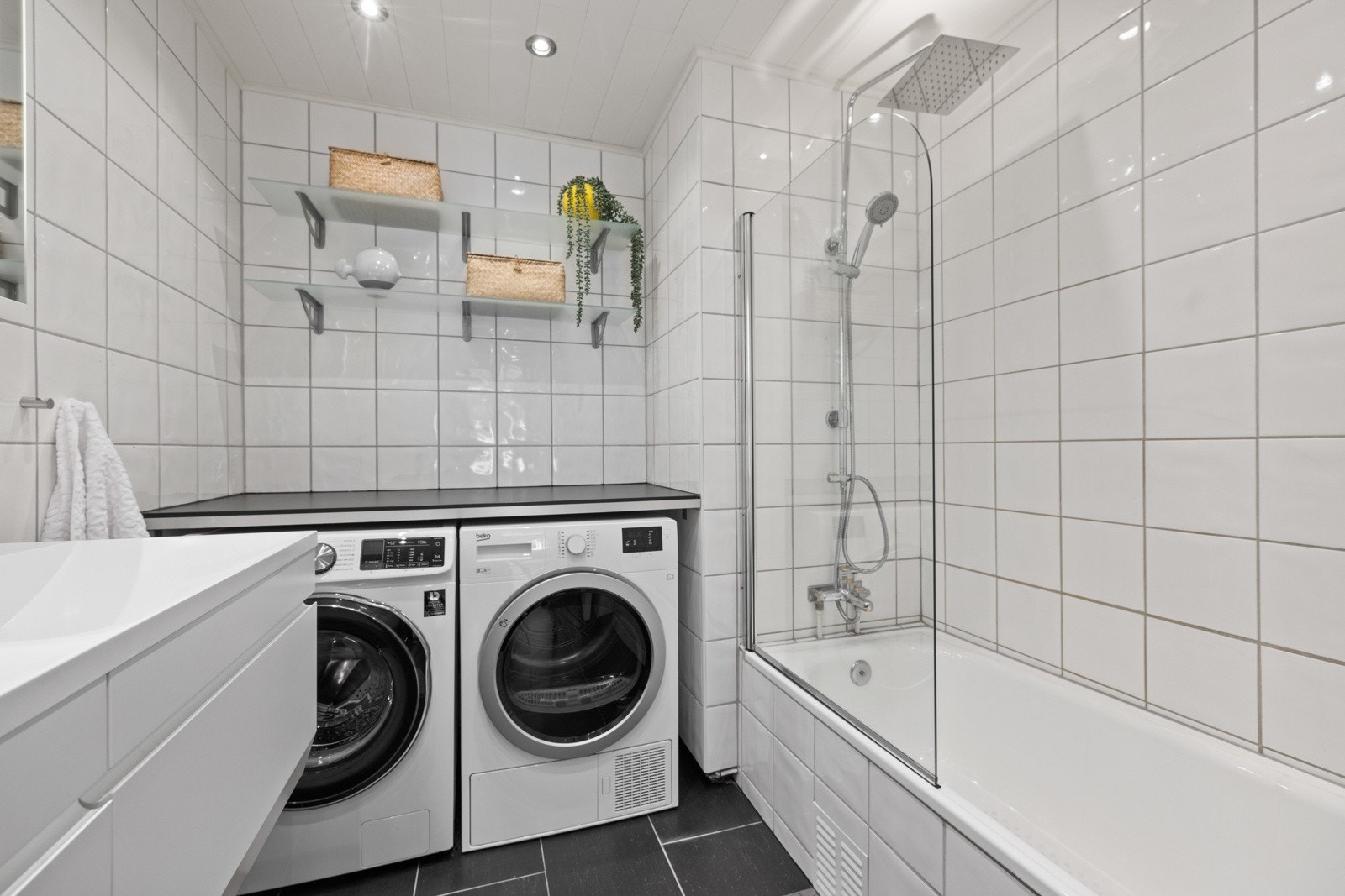 Badet har downlights i himling, varme i gulvet og egen vaskeromssone i smart nisje med plass til både vaskemaskin og tørketrommel Galleribilde
