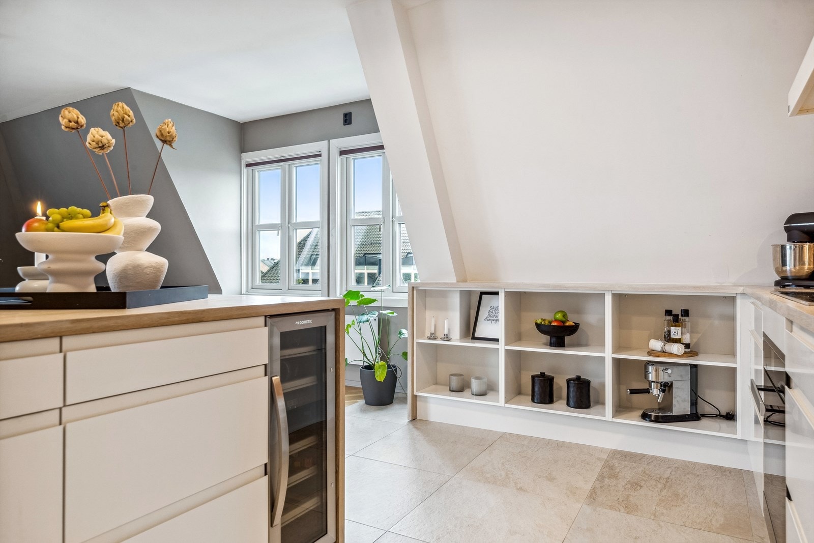 Kjøkkenet har også plassbygde hyller, takhøye skap og heltre benkeplate. Galleribilde