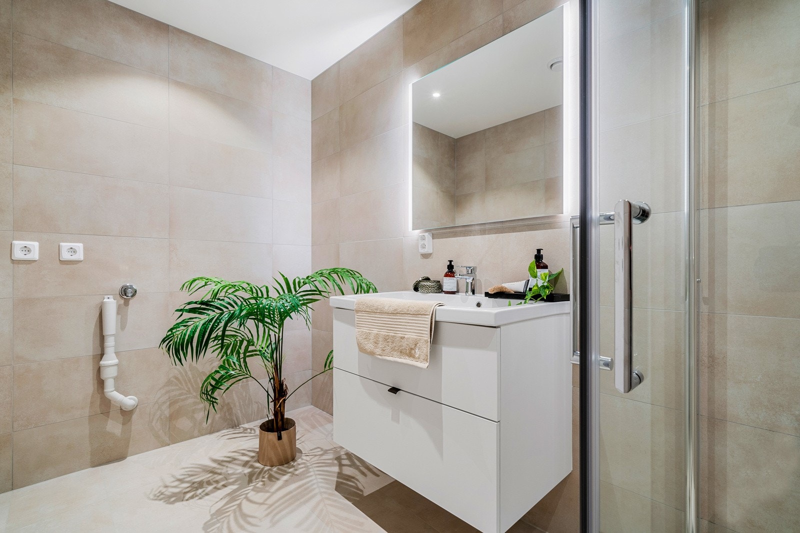 - Badet er det utstyrt med baderomsmøbel med overliggende speil og belysning, vegghengt toalett og dusjhjørne med glassdører og plass til vaskesøyle - Galleribilde