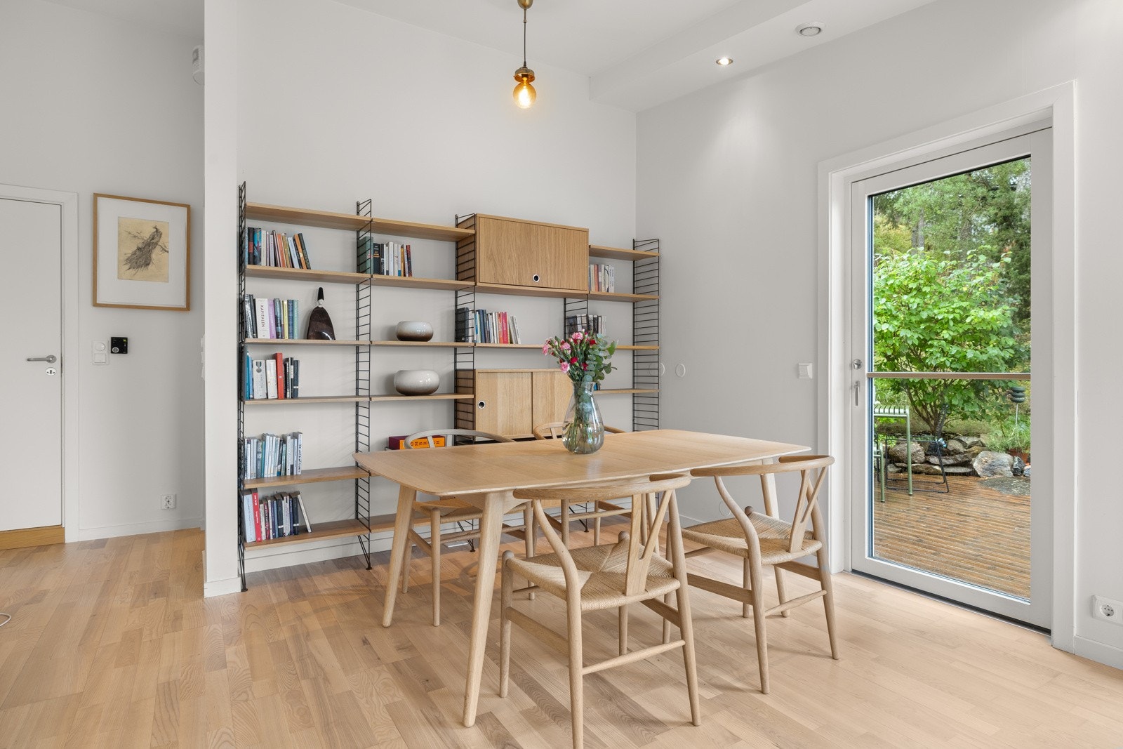 Veggflater malt i en lys og stilren farge, og gulvflater i lys parkett, gir rommet et tidløst preg Galleribilde