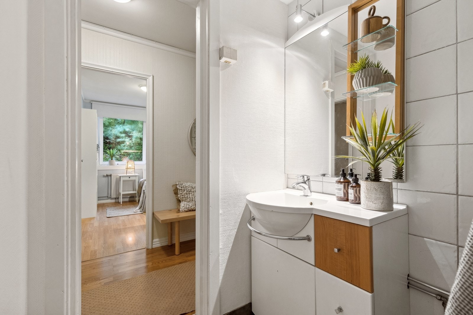 Leiligheten har et pent bad med fliser på gulvet, og fliser og strie på veggene. Galleribilde