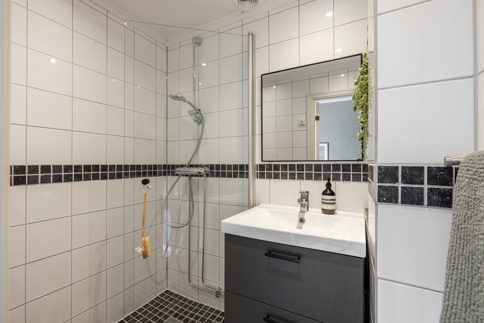Flislagt baderom av god størrelse som fremstår stilrent og tidløst - behagelig gulvvarme gir badet en lun atmosfære Galleribilde