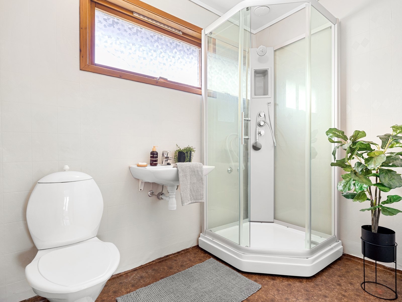 Bad med belegg på gulv og våtromstapet. Dusjkabinett, wc og vask. Galleribilde