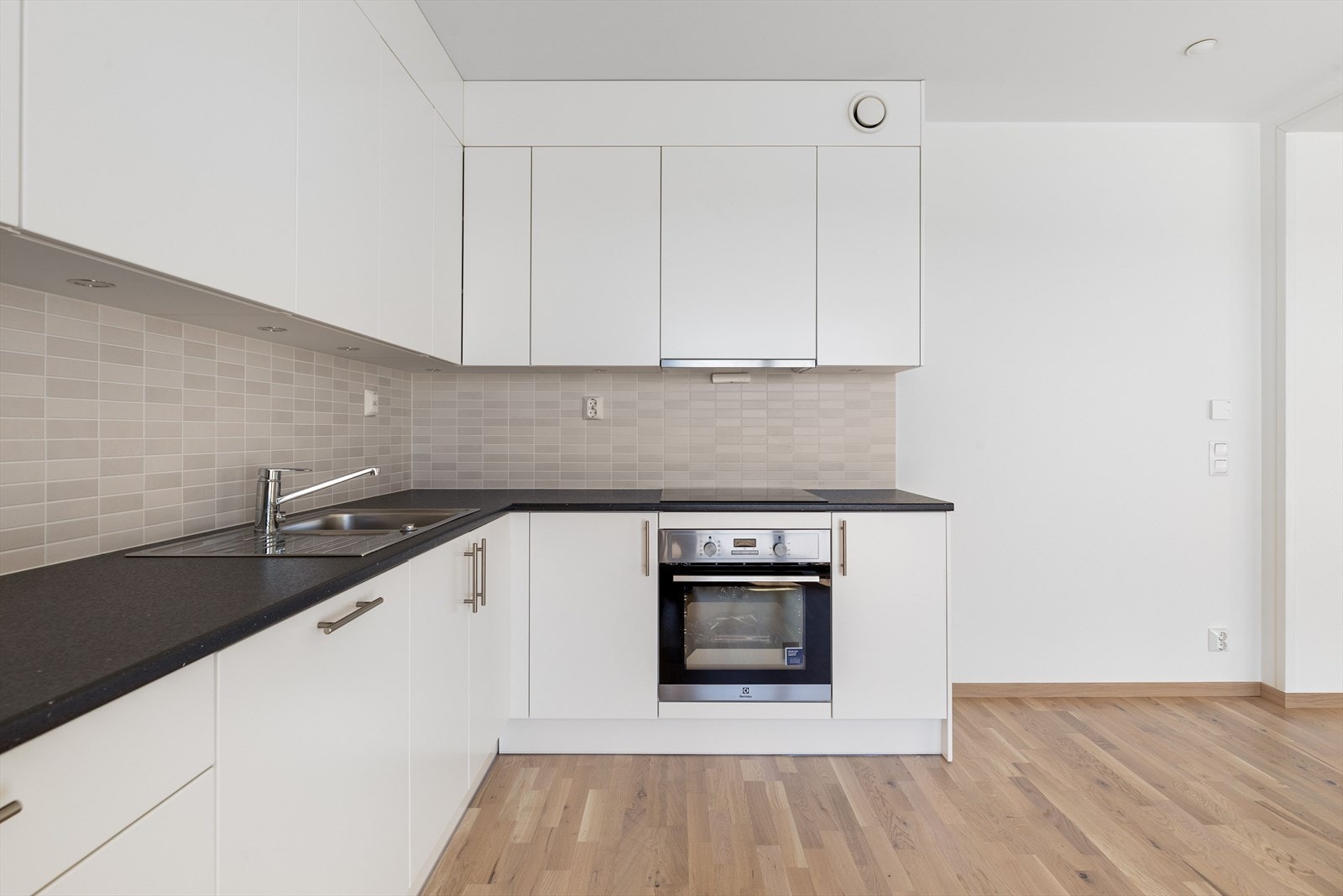 Pent kjøkken med glatte overflater og kraftig benkeplate Galleribilde