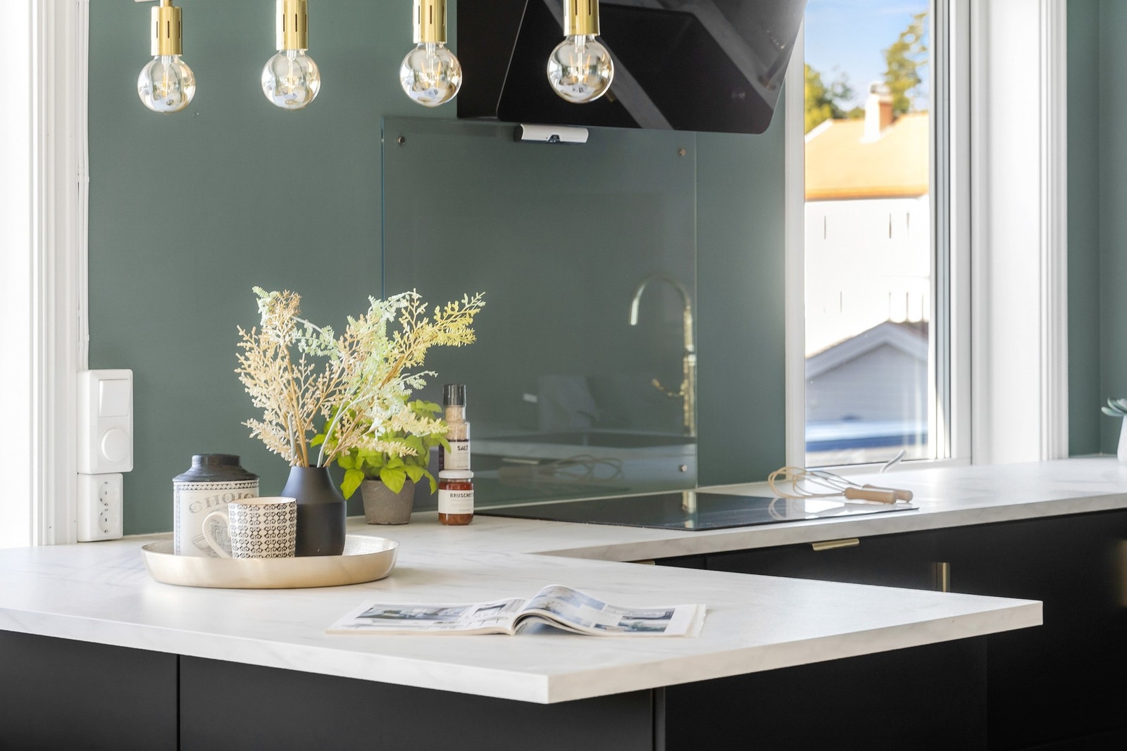 Laminat benkeplate med glassplater over benk ved koketopp og vask. Integrert koketopp, stekeovn, mikrobølgeovn, benkekjøleskap og oppvaskmaskin. Galleribilde