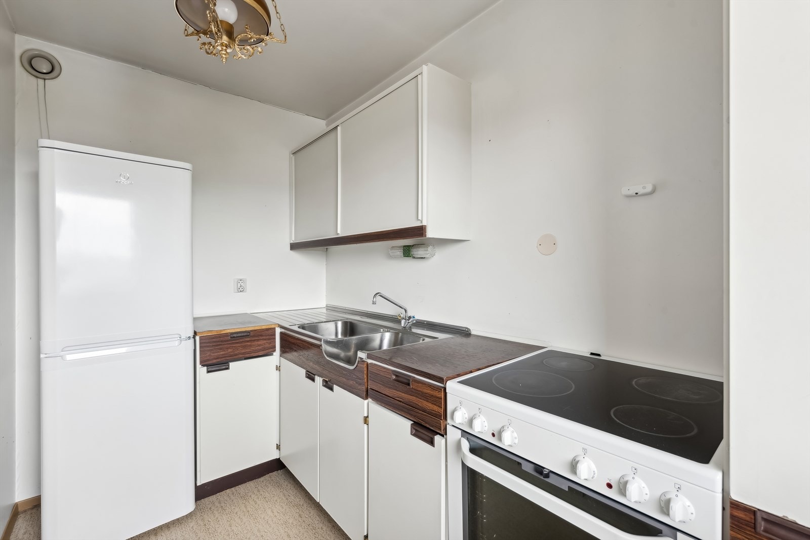 Det er fronter av laminat med skyvedører på overskap, laminat benkeplate og heldekkende nedfelt stål benkebeslag. Galleribilde