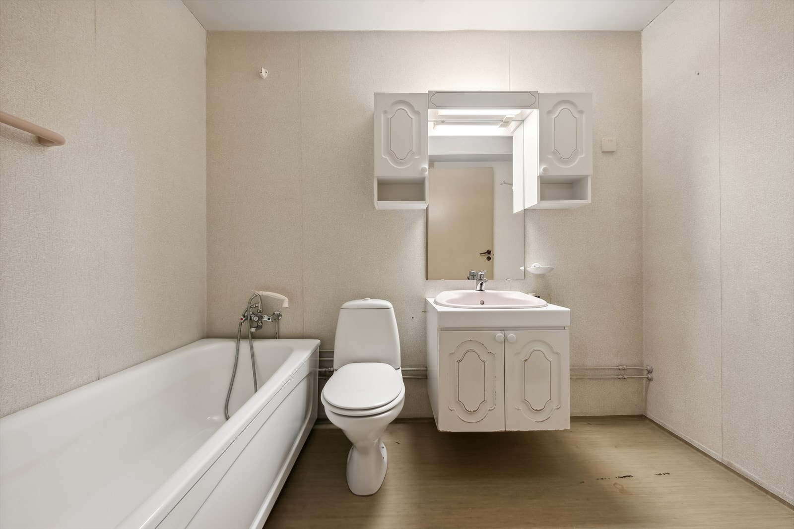 Badet er utstyrt med badekar med dusjhode, klosett, nedfelt servant, opplegg for vaskemaskin. Det er vinylbelegg på gulvet og våtromstapet på veggene. Det er også varmekabler i gulvet. Galleribilde