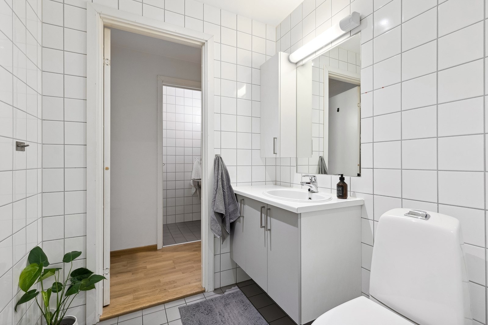 Badet er innredet med servant i innredning, toalett og dusjhjørne. Galleribilde
