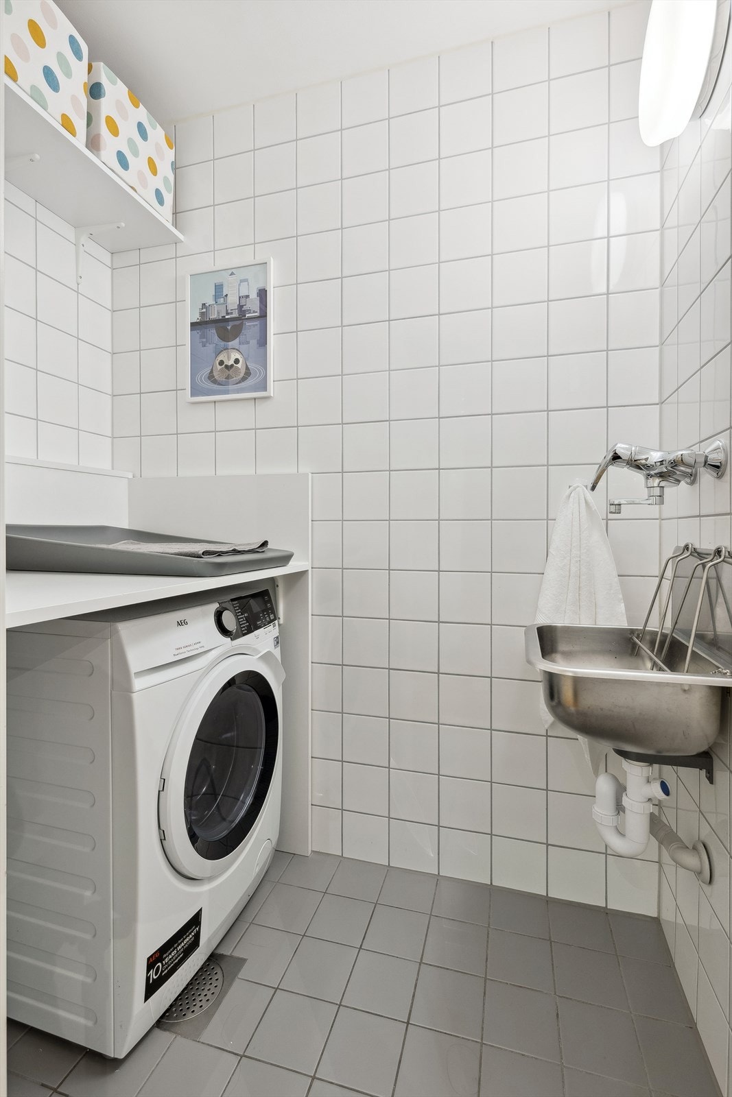 Praktisk vaskerom med utslagsvask og opplegg for vaskemaskin. Galleribilde