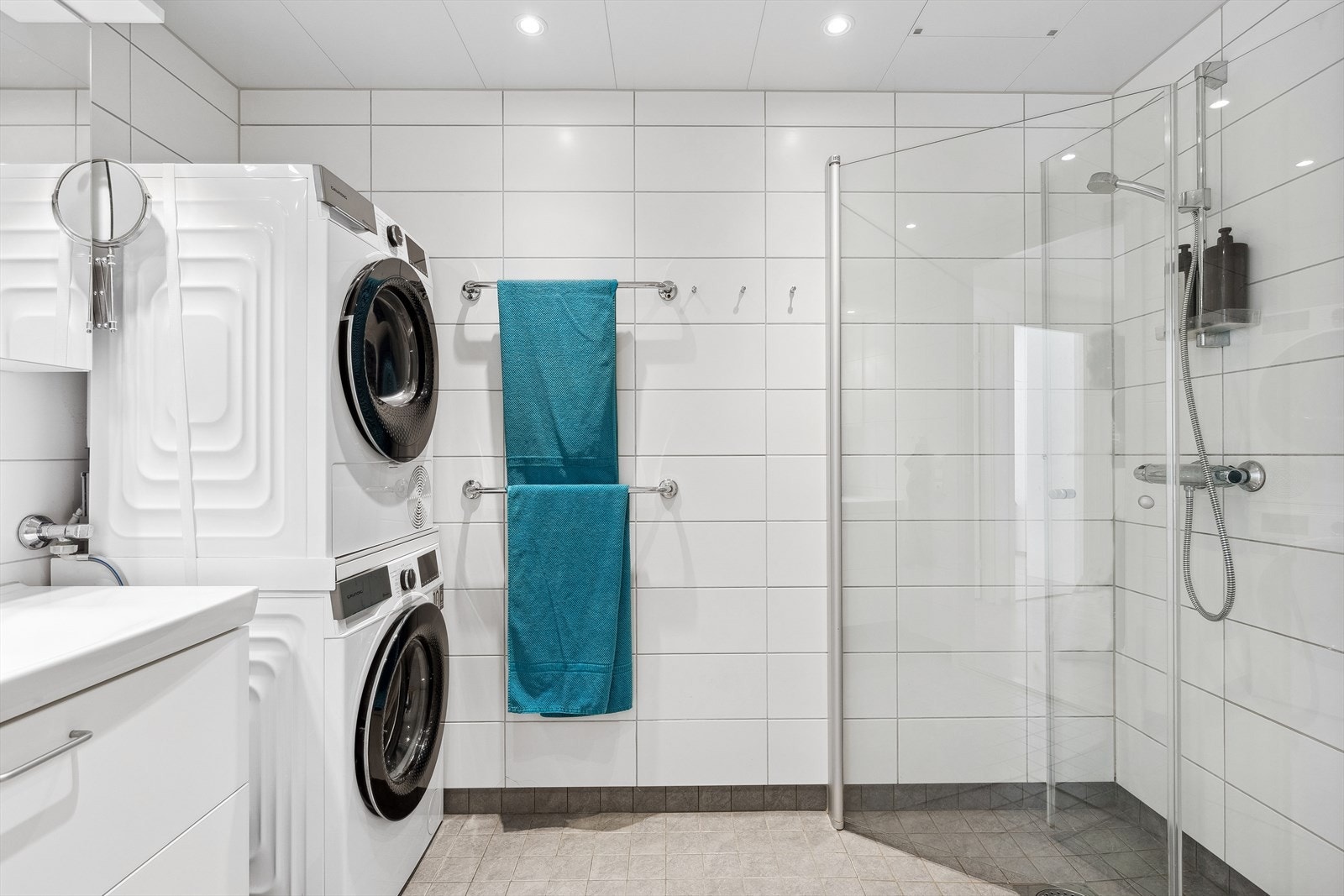 Pent flislagt bad med servant og dusj. God plass til oppbevaring av både vaskemaskin og tørketrommel. Galleribilde