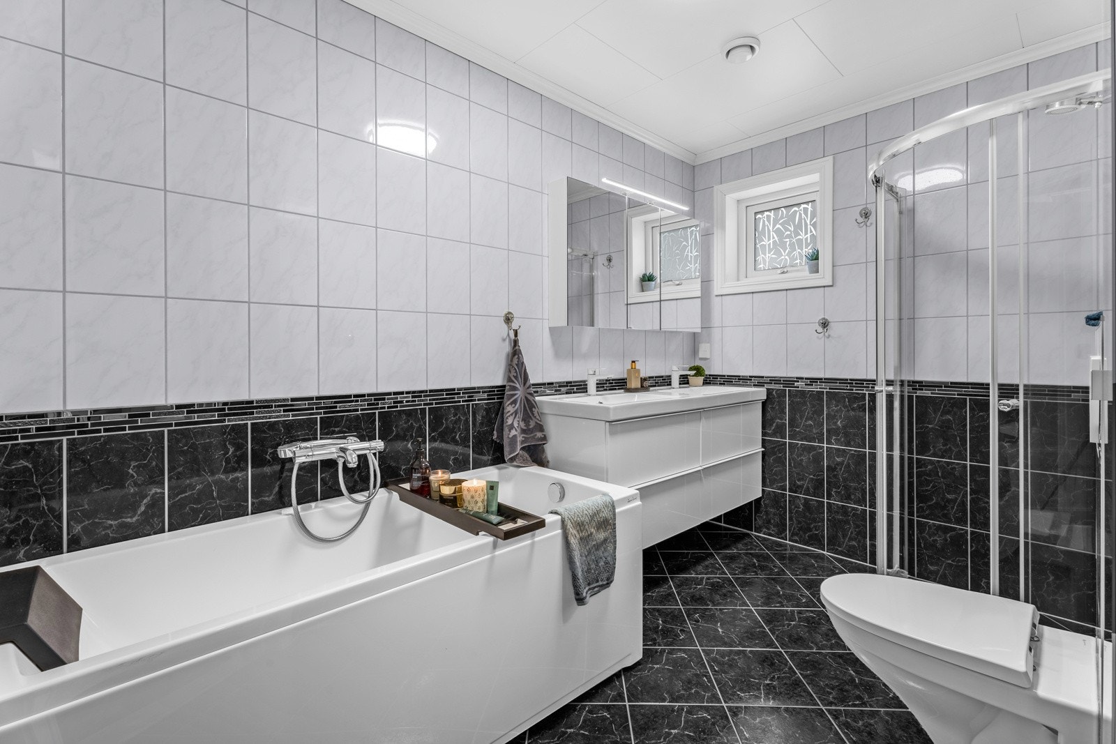Badet ligger i første etasje og har fokus på velvære, for her er det både dusjhjørne med dører i herdet glass og et frittstående badekar med dusjmuligheter Galleribilde