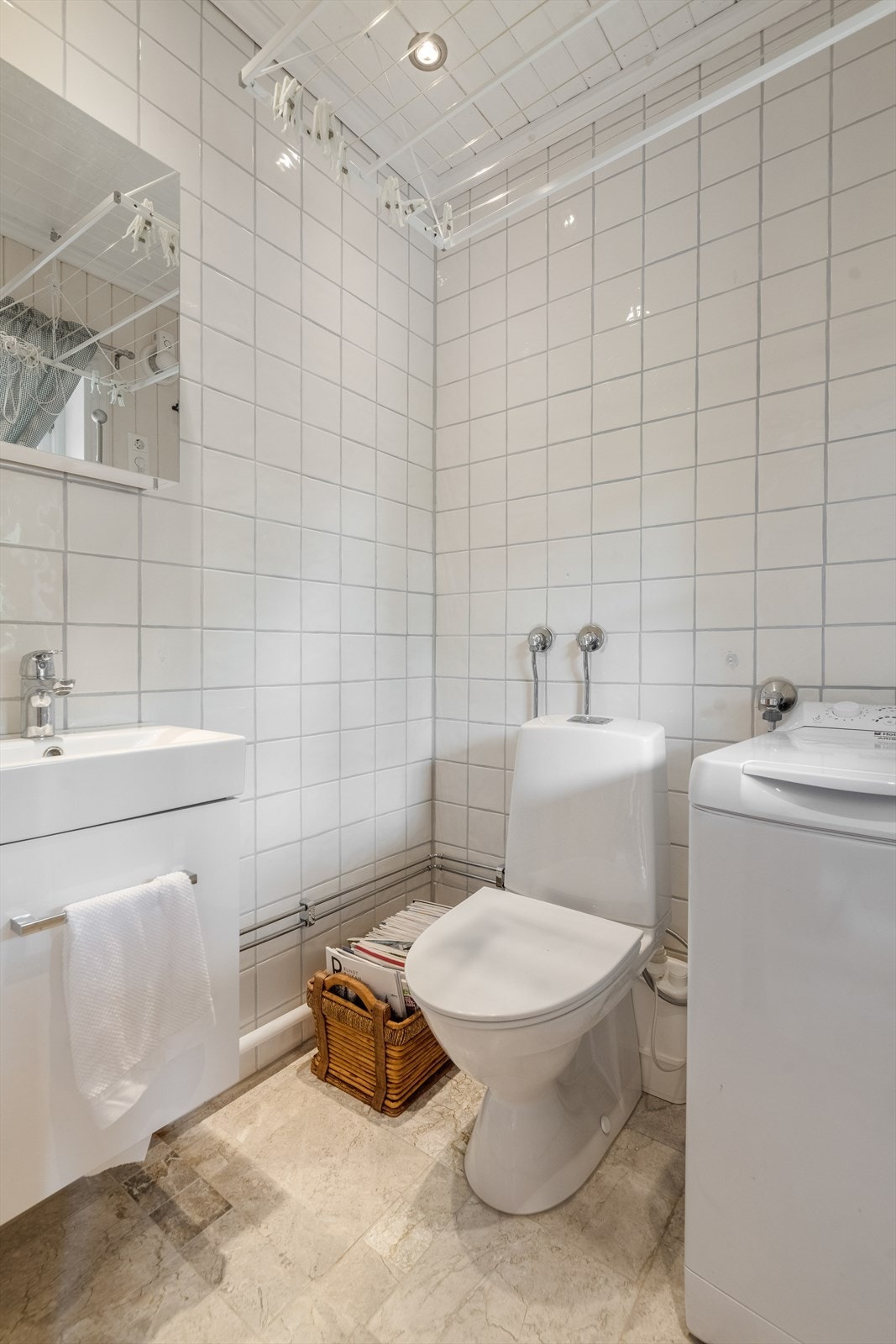 Inntil vindfanget er det etablert eget toalettrom hvor det også er fliser på gulv med varmekabler. Her er det innredet med servantskap og toalett med kvernløsning. Rommet har også opplegg for og plass til vaskemaskin. Galleribilde