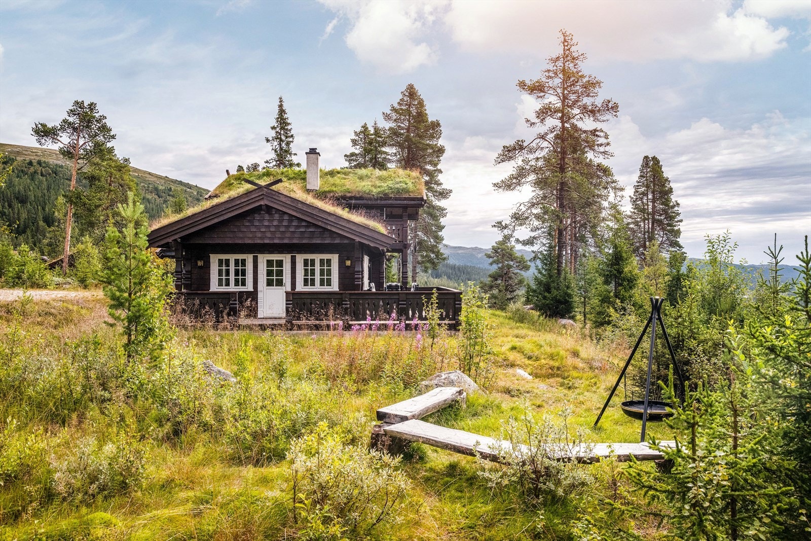 Terrenget rundt hytta består hovedsakelig av naturtomt med lyng og mose, og det er opparbeidet en koselig bålpanneplass noen meter fra terrassen. Galleribilde